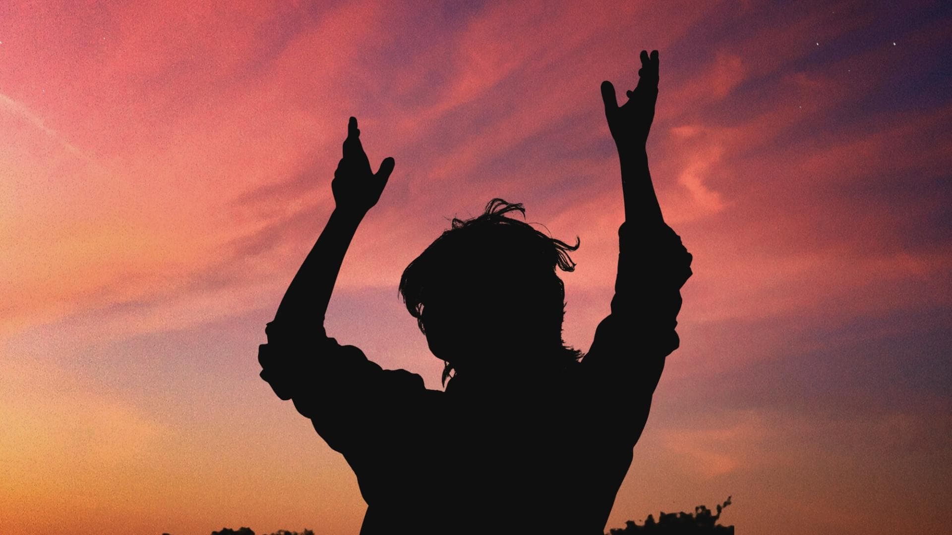 Schatten einer Frau, die die Hände in den Himmel hält