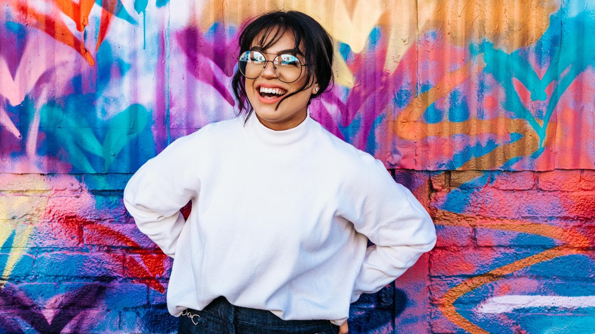 Horoskop Glück: Frau vor einer bunten Wand