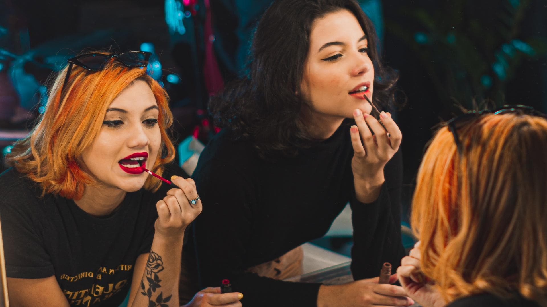 Zwei Frauen schminken sich im Spiegel