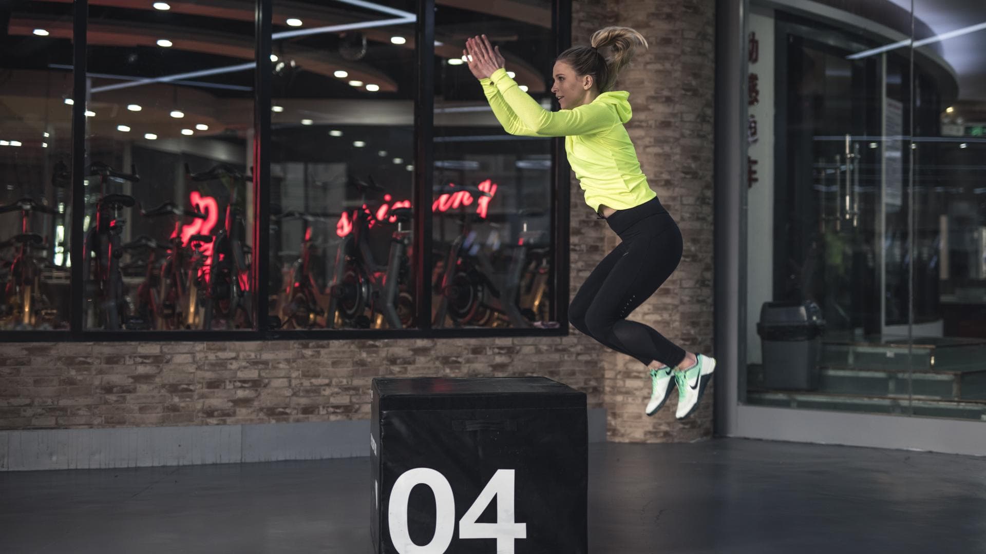 frau springt über block fitness leggings