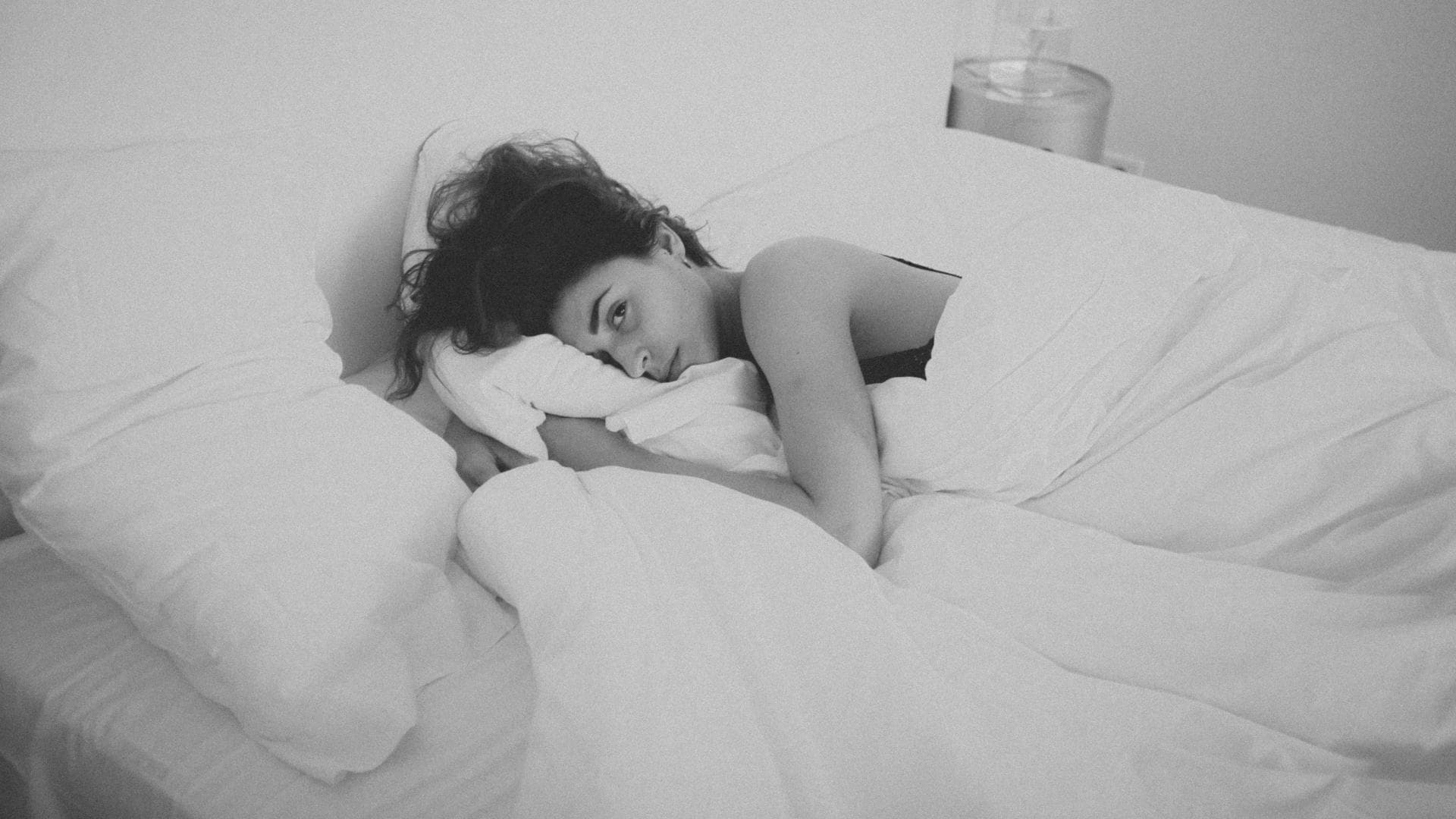 frau nackt im bett traurig 