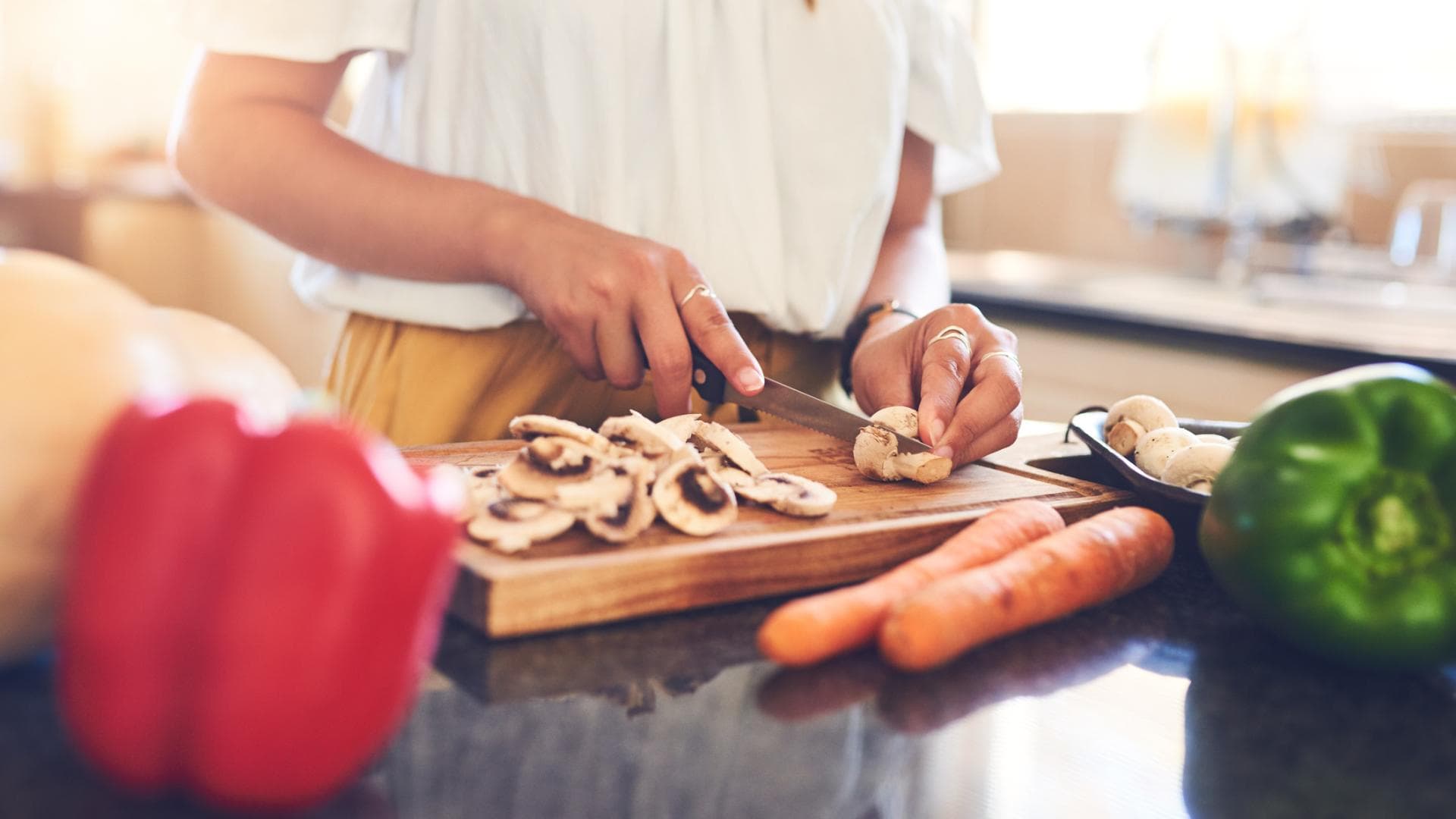 frau schneidet gemüse in der küche abnehmen diät