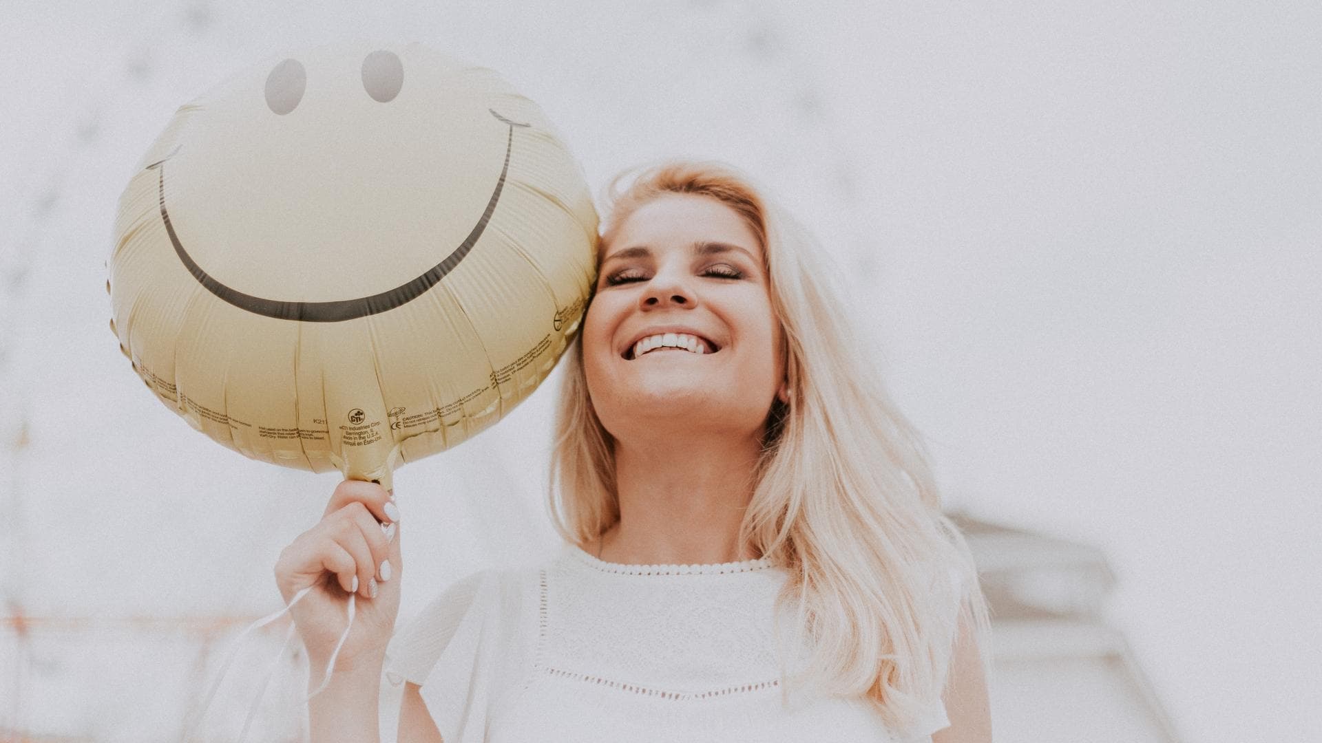 Frau lacht mit Ballon