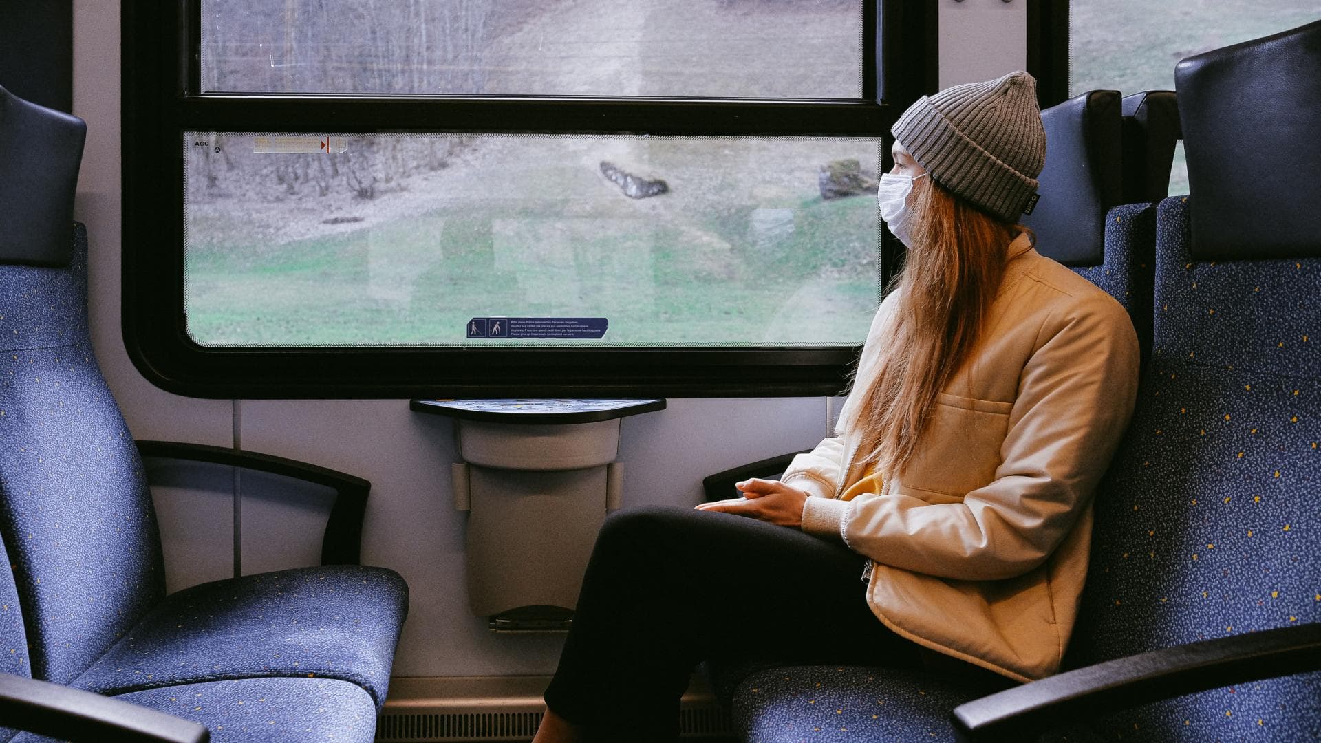 Mädchen im Zug mit Atemmaske