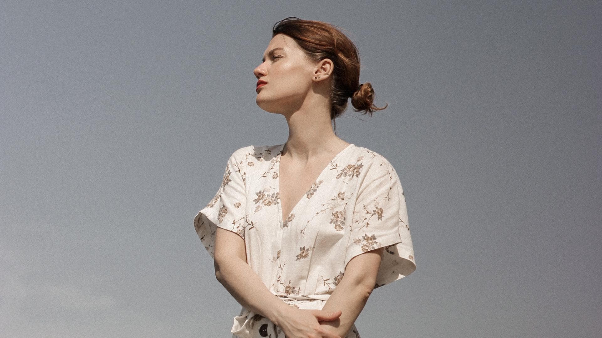 Frau im Kleid vor einem grauen Hintergrund