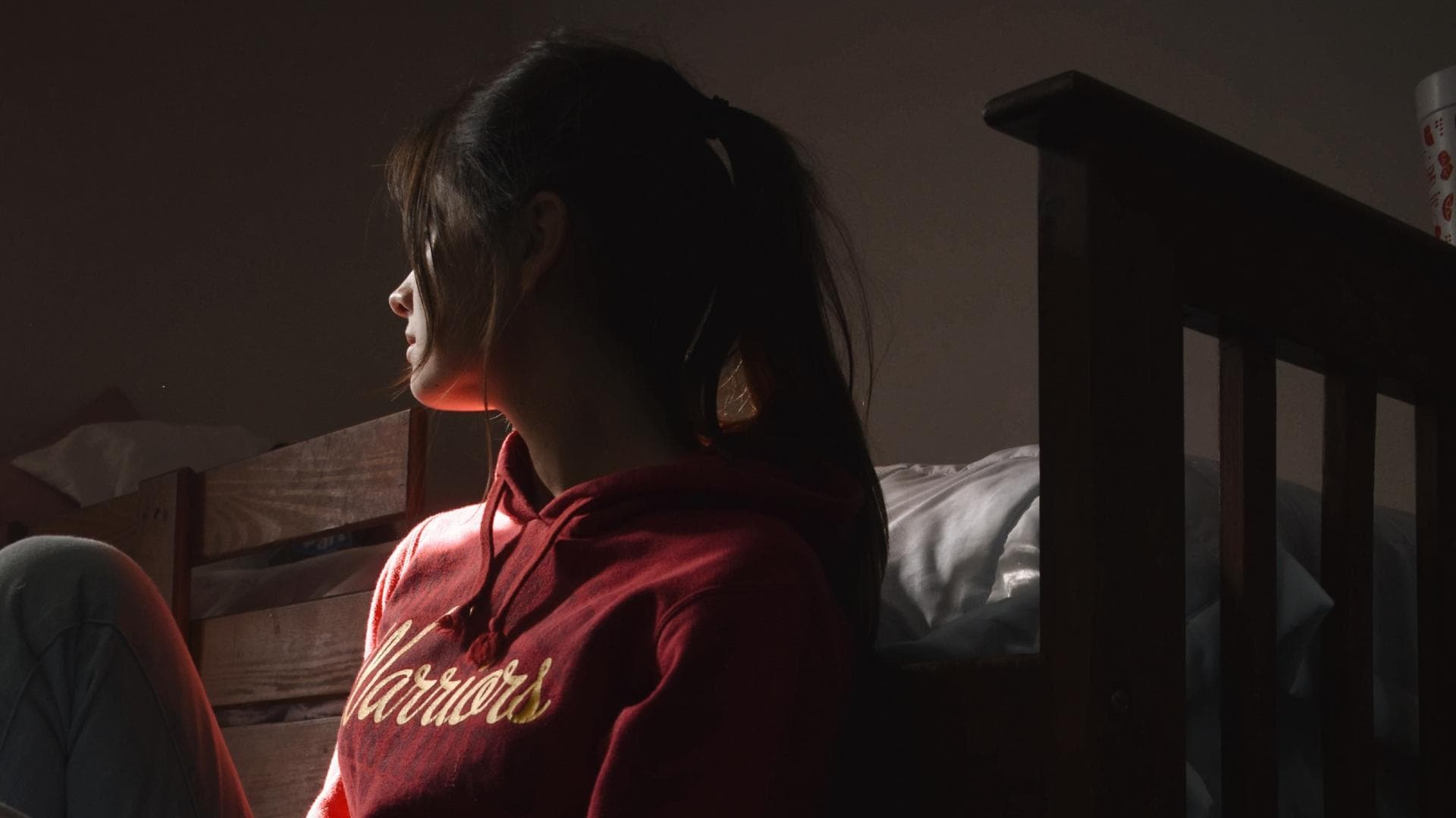 Mädchen auf Fußboden vor Bett