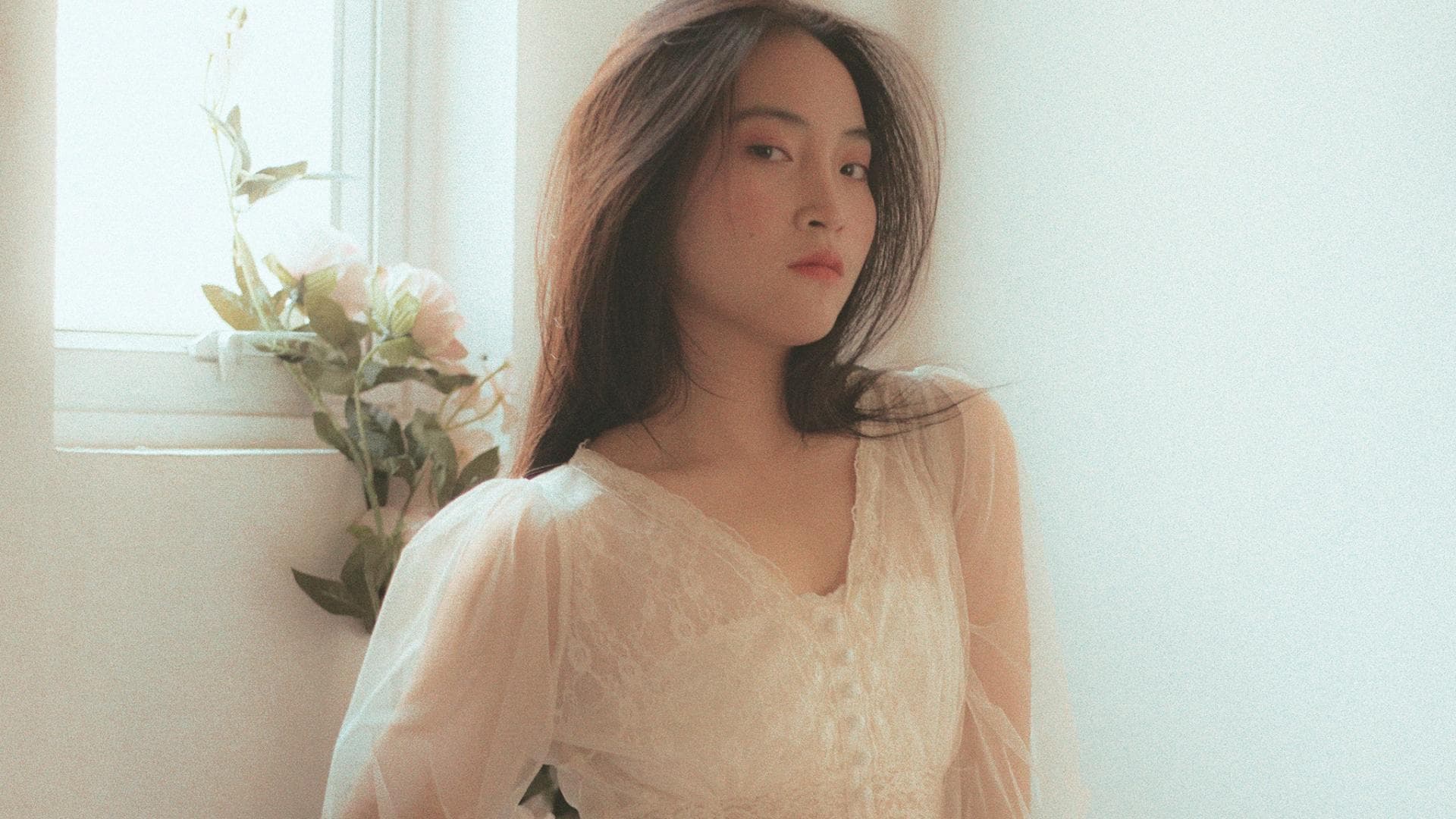 Frau mit weißem Kleid auf einem Bett