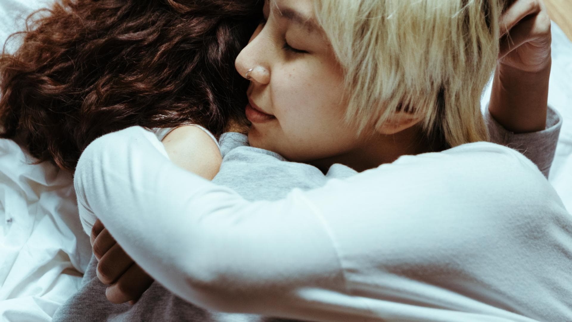 Zwei Frauen umarmen sich im Liegen