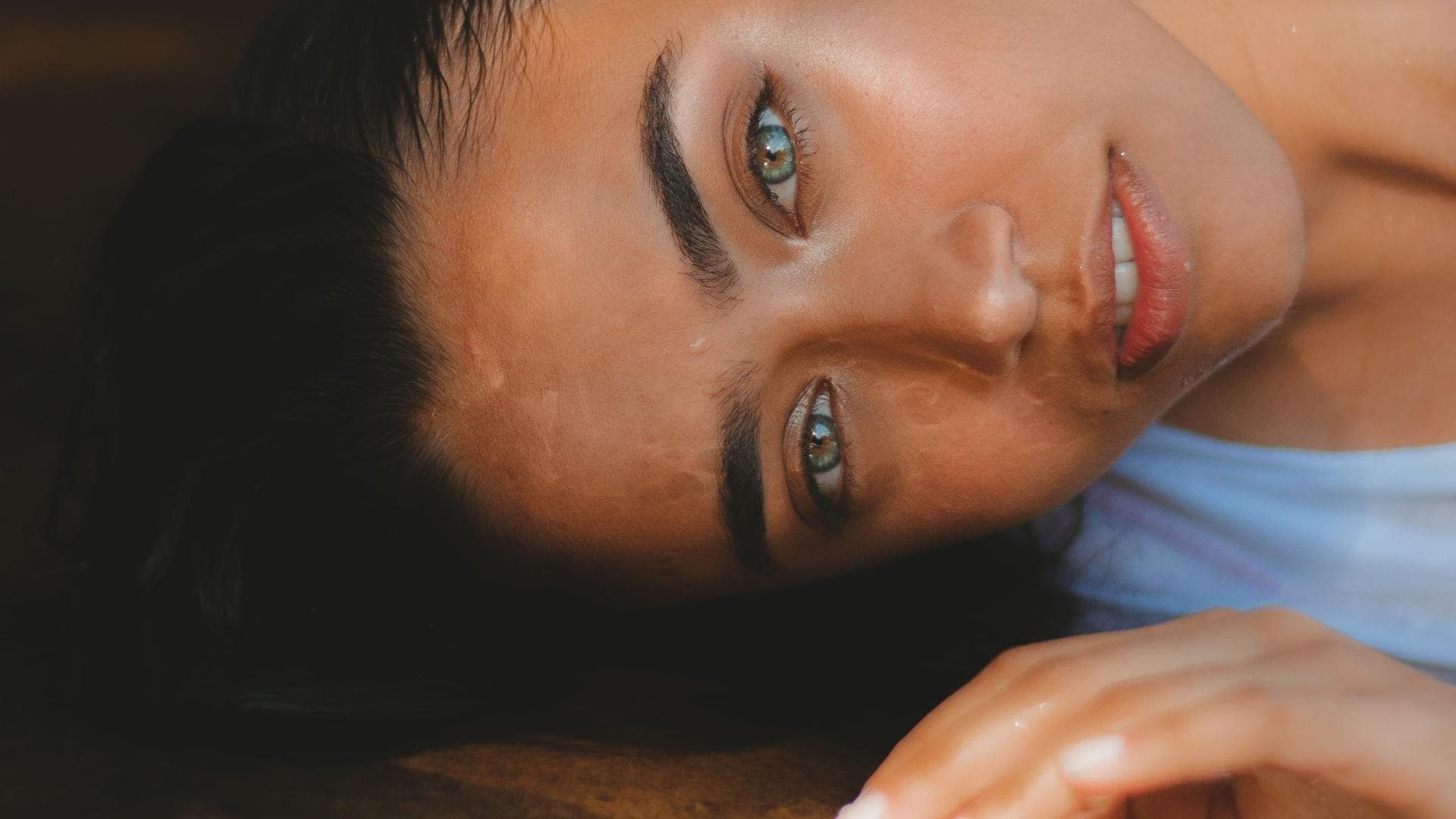 Frau liegt auf dem Boden und schaut in die Kamera