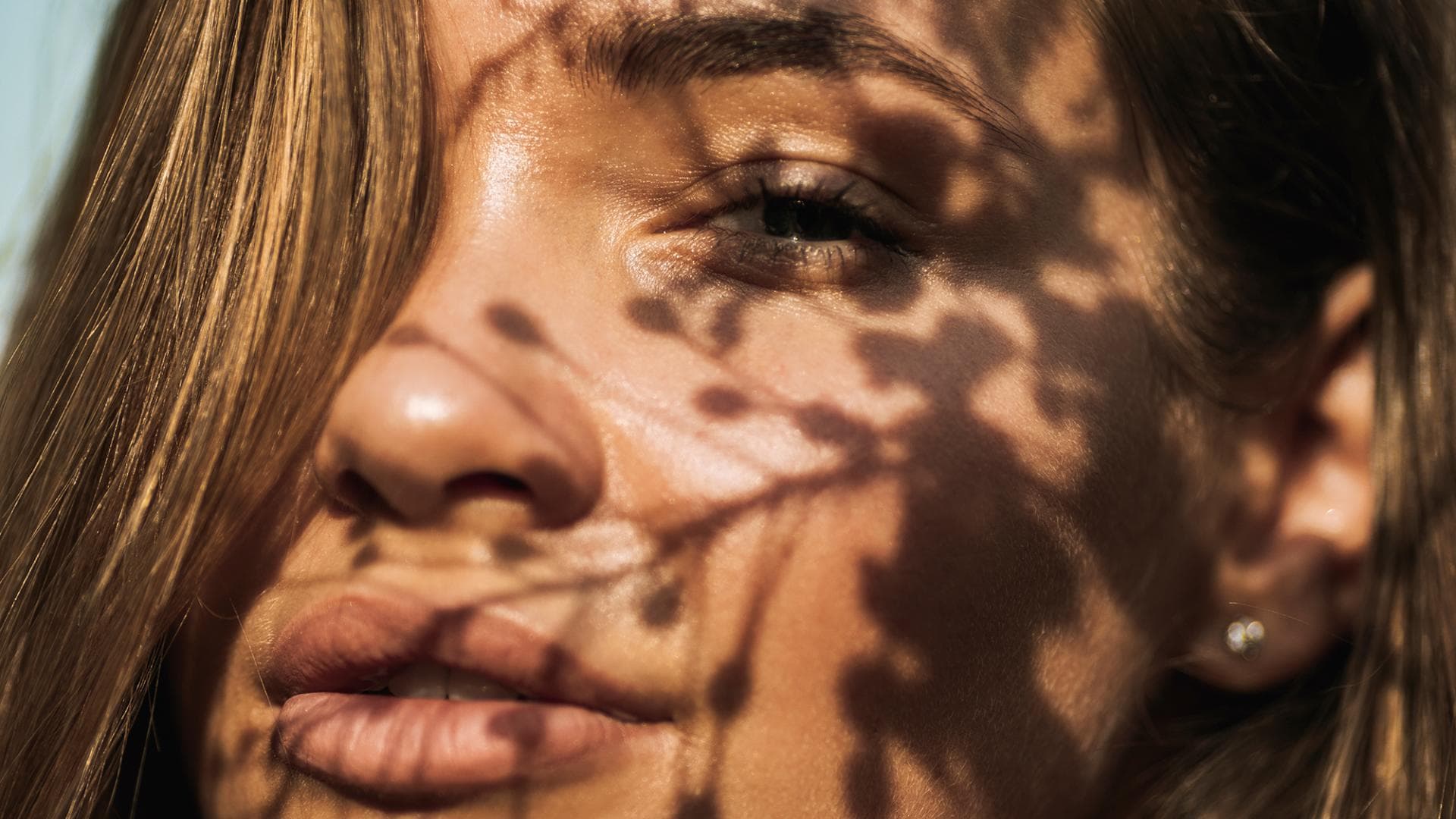 Frau scheint Sonne ins Gesicht