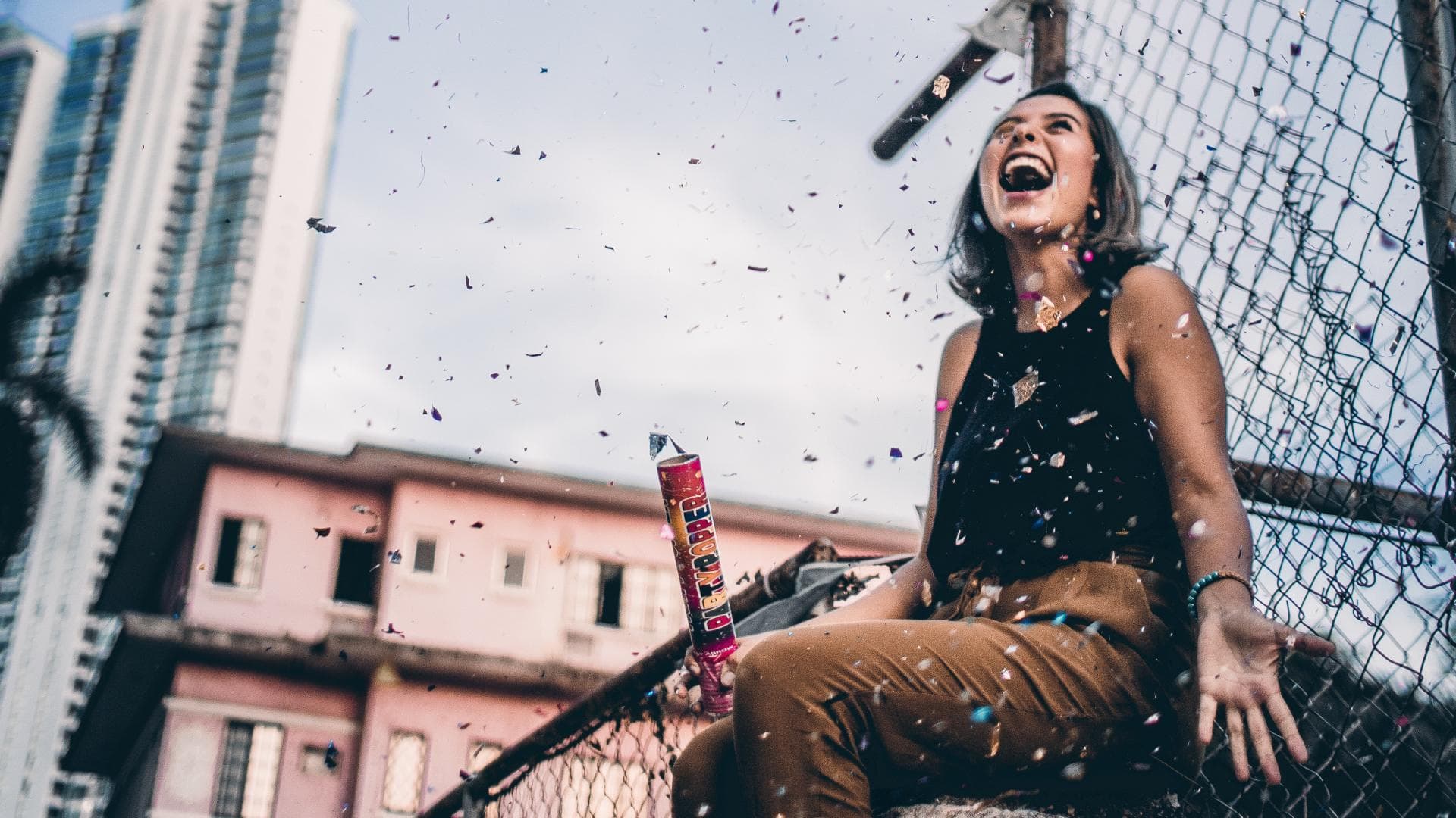 Frau sitzt in Konfetti und lacht