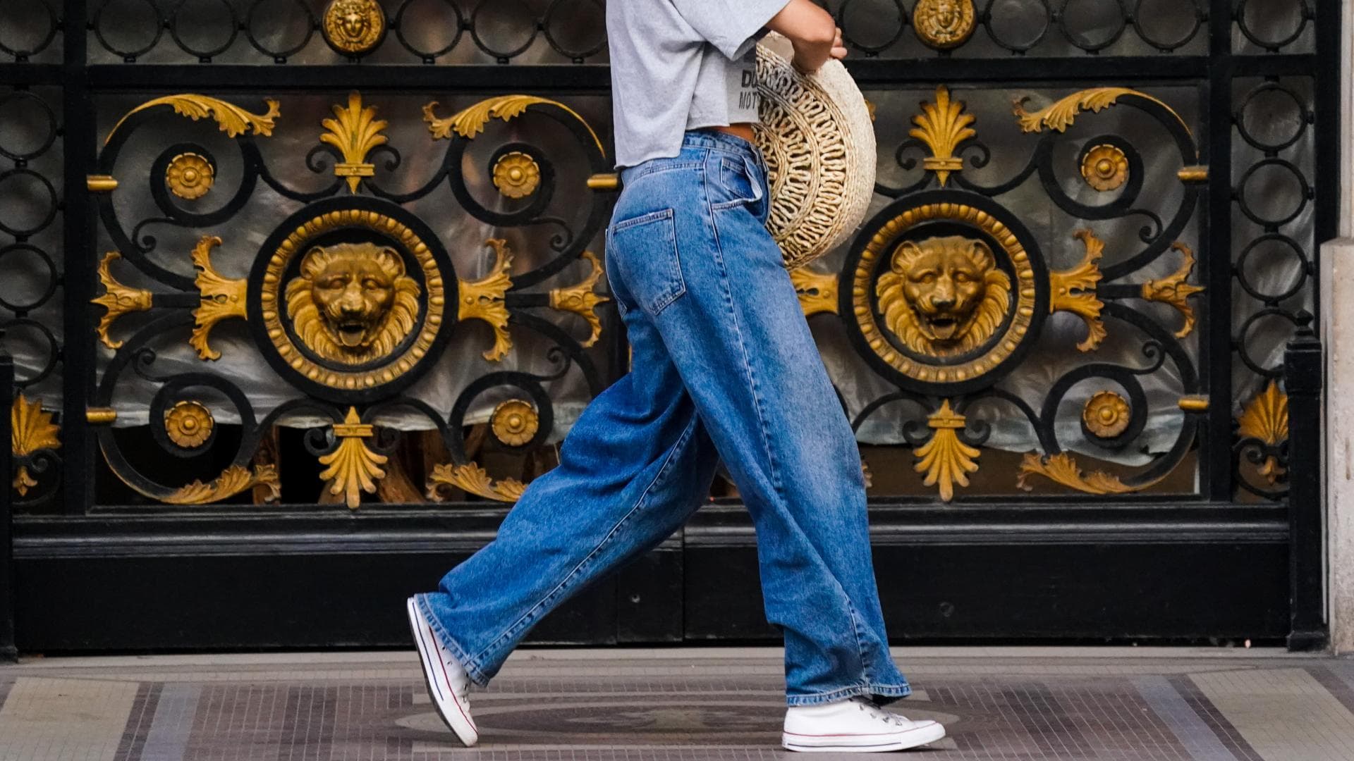 Frau trägt weite Jeanshose und Chucks