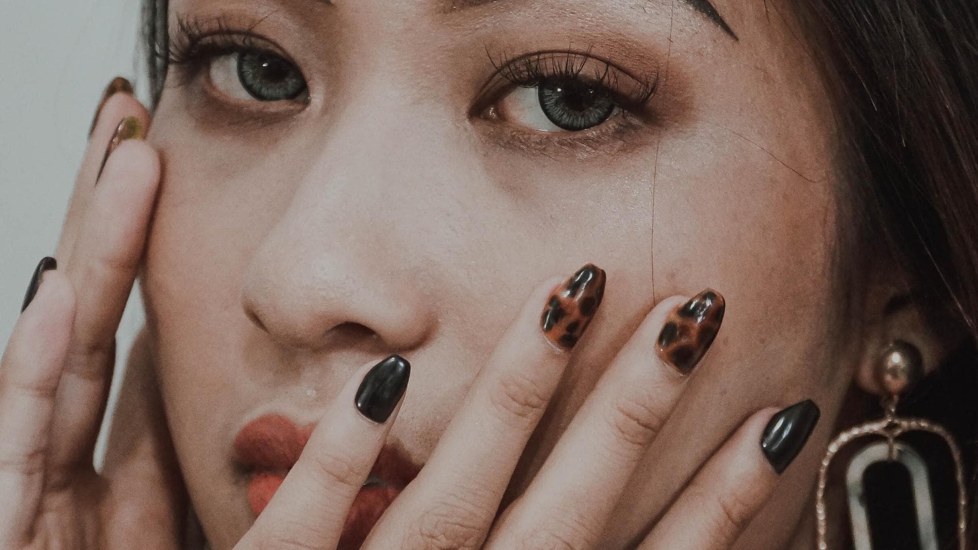 Brünettes Mädchen mit Händen im Gesicht