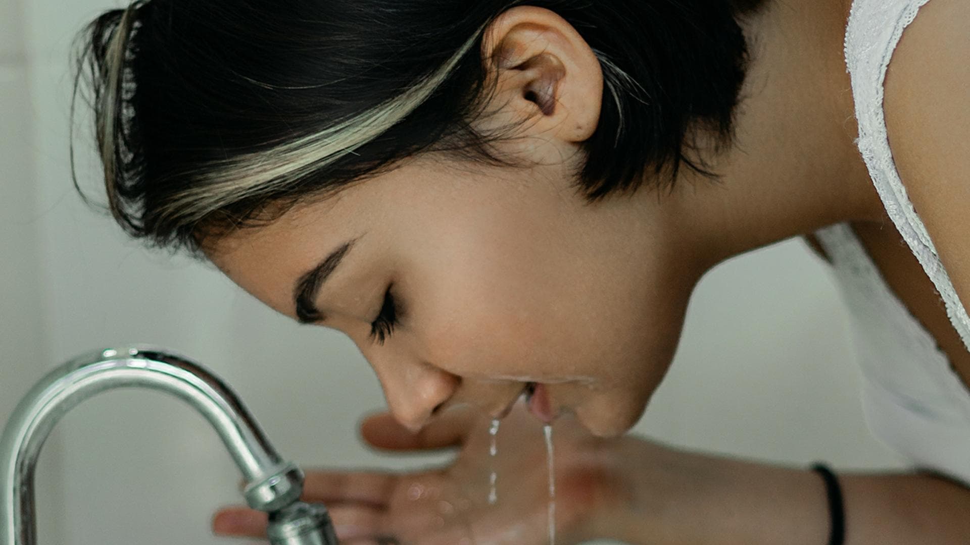 Mädchen wäscht sich im Waschbecken ihr Gesicht