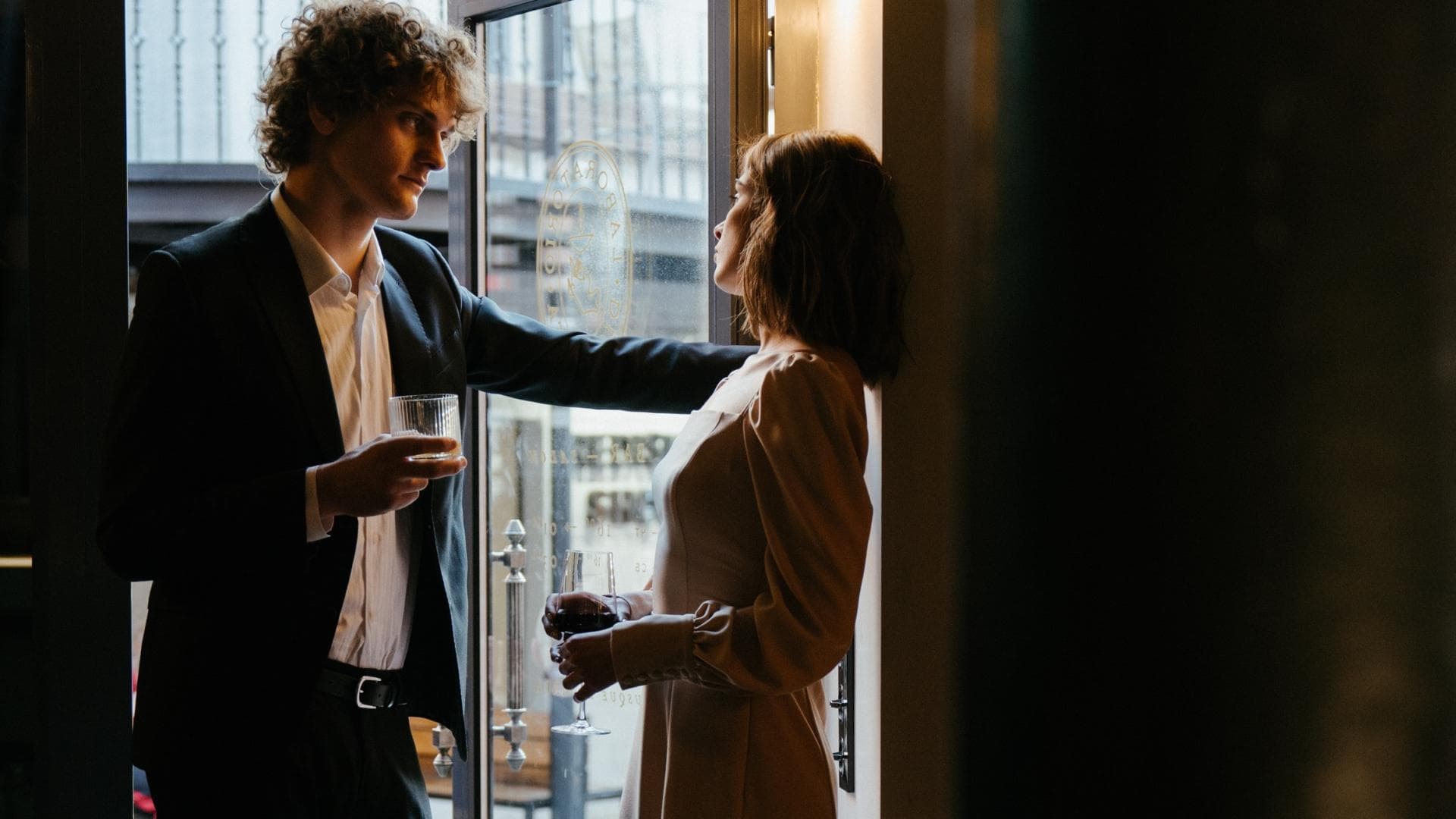 Erstes Date: Paar steht mit Weingläsern in der Tür