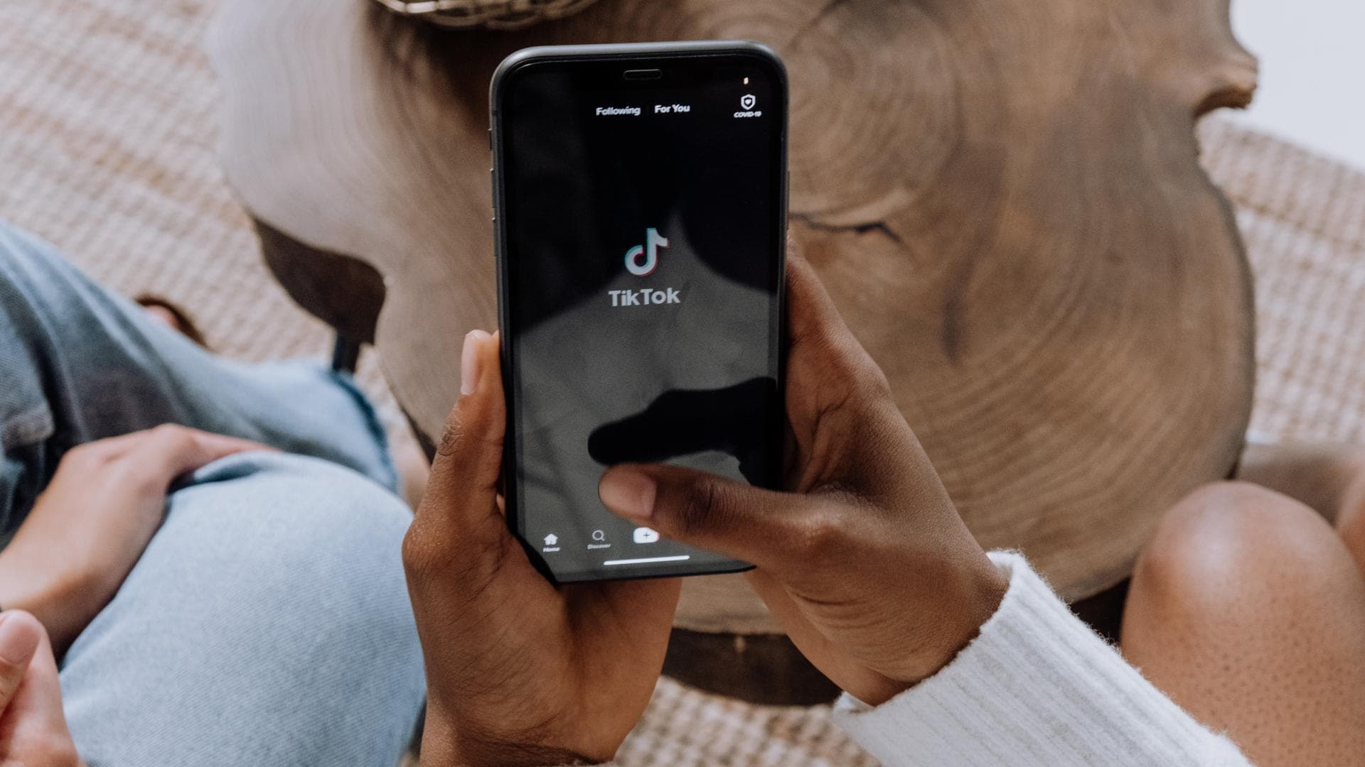 Frau hält Handy mit TikTok App hoch