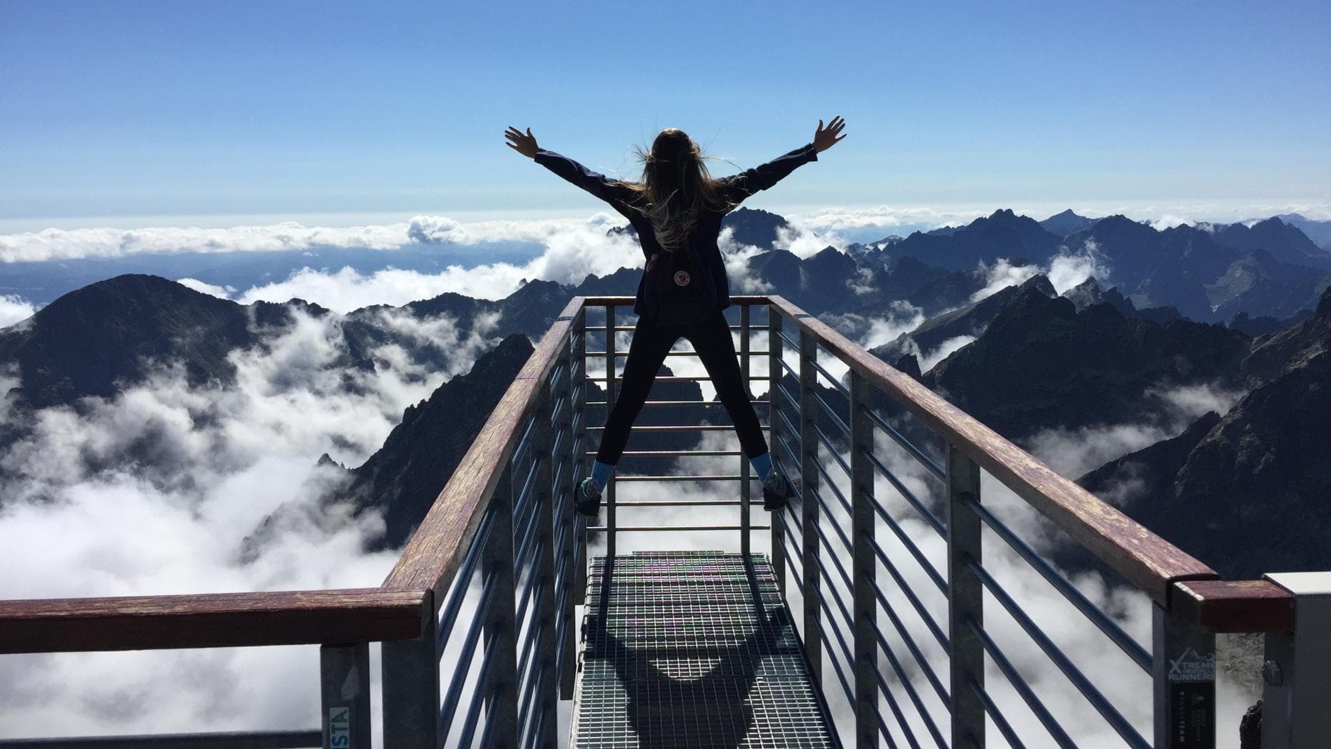 Frau steht auf einem Berg