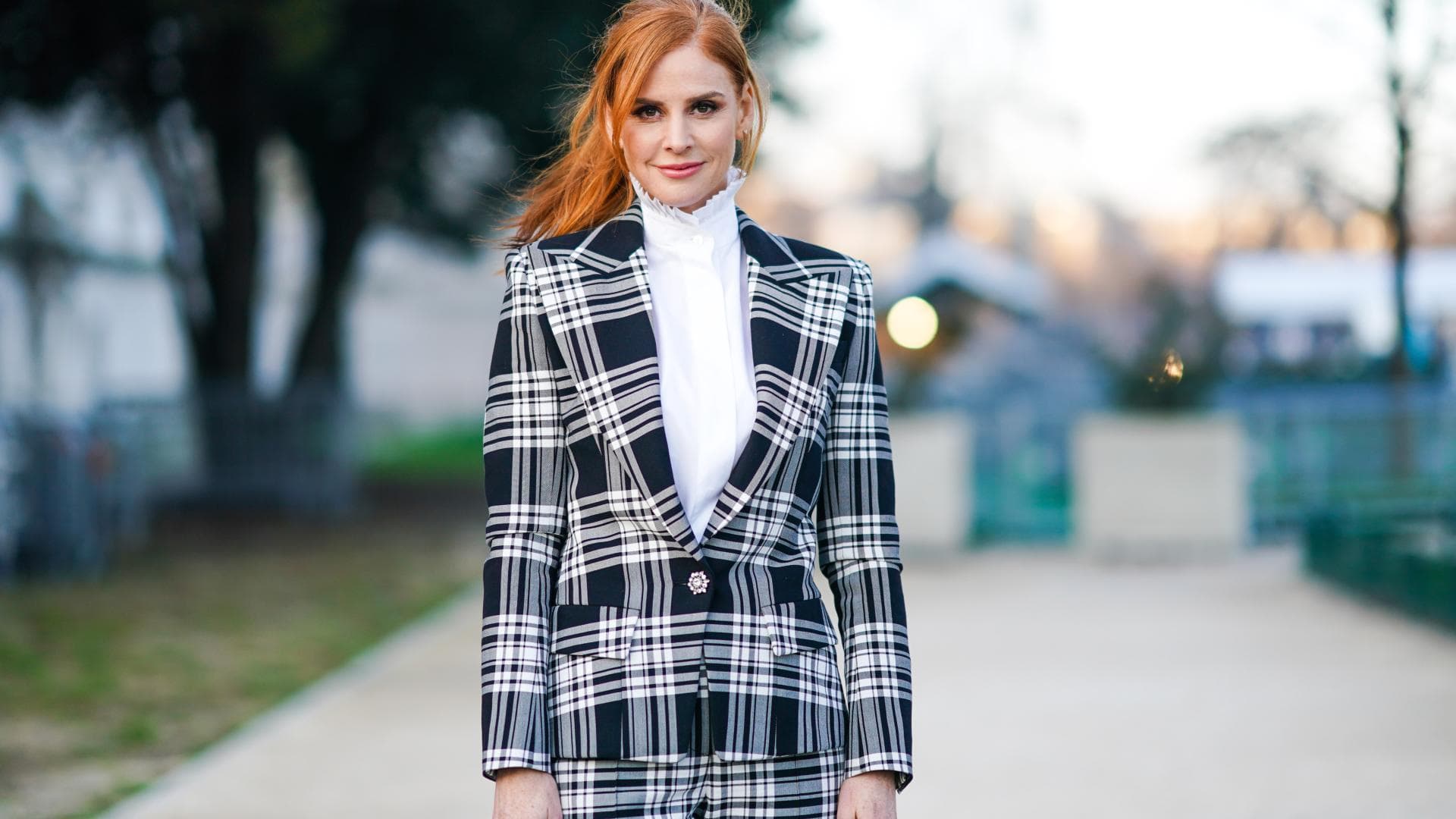 Bloggerin mit roten Haaren, trägt Karo-Anzug