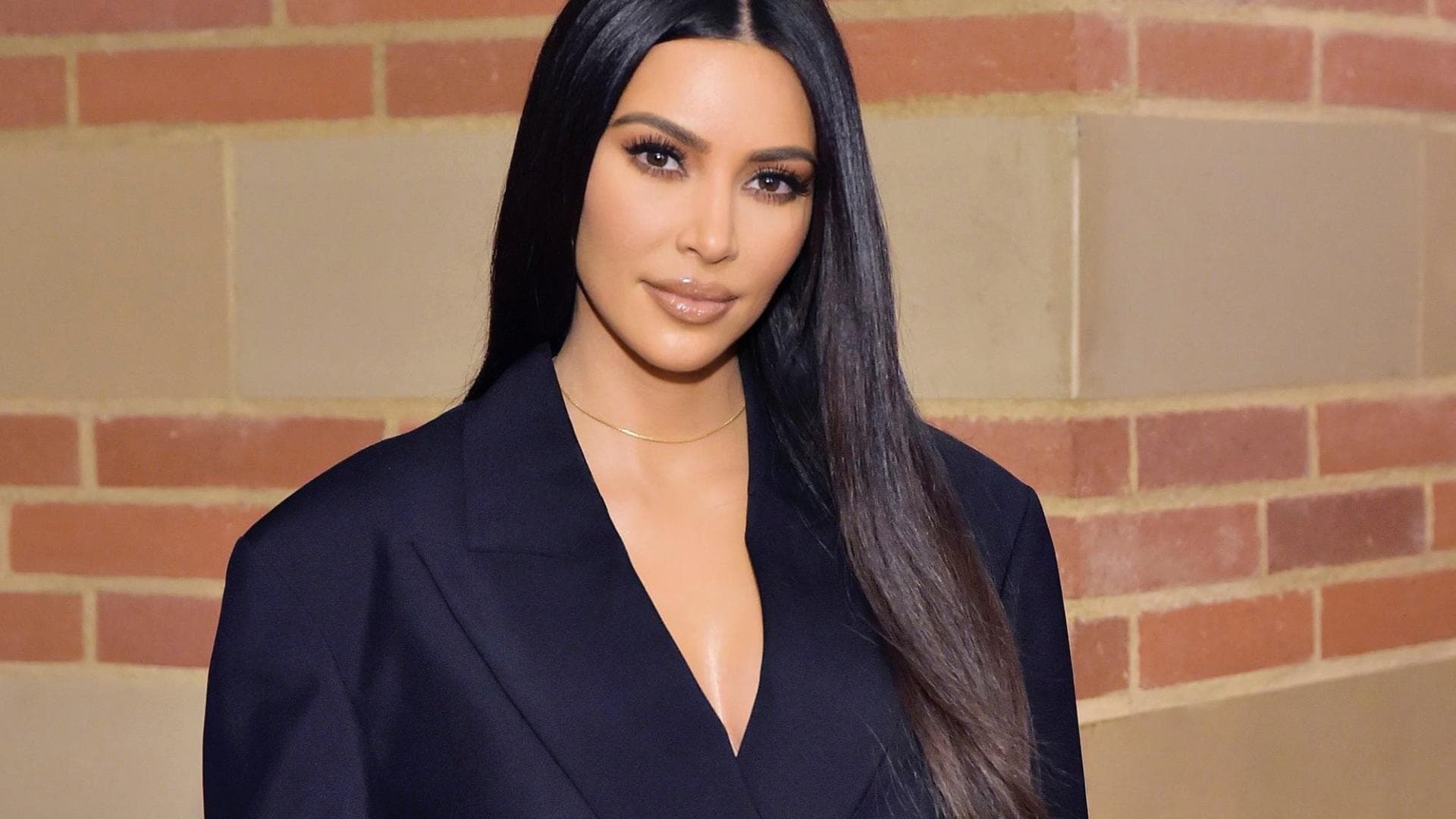 Kim Kardashian in schwarzem Anzug, lange Haare 