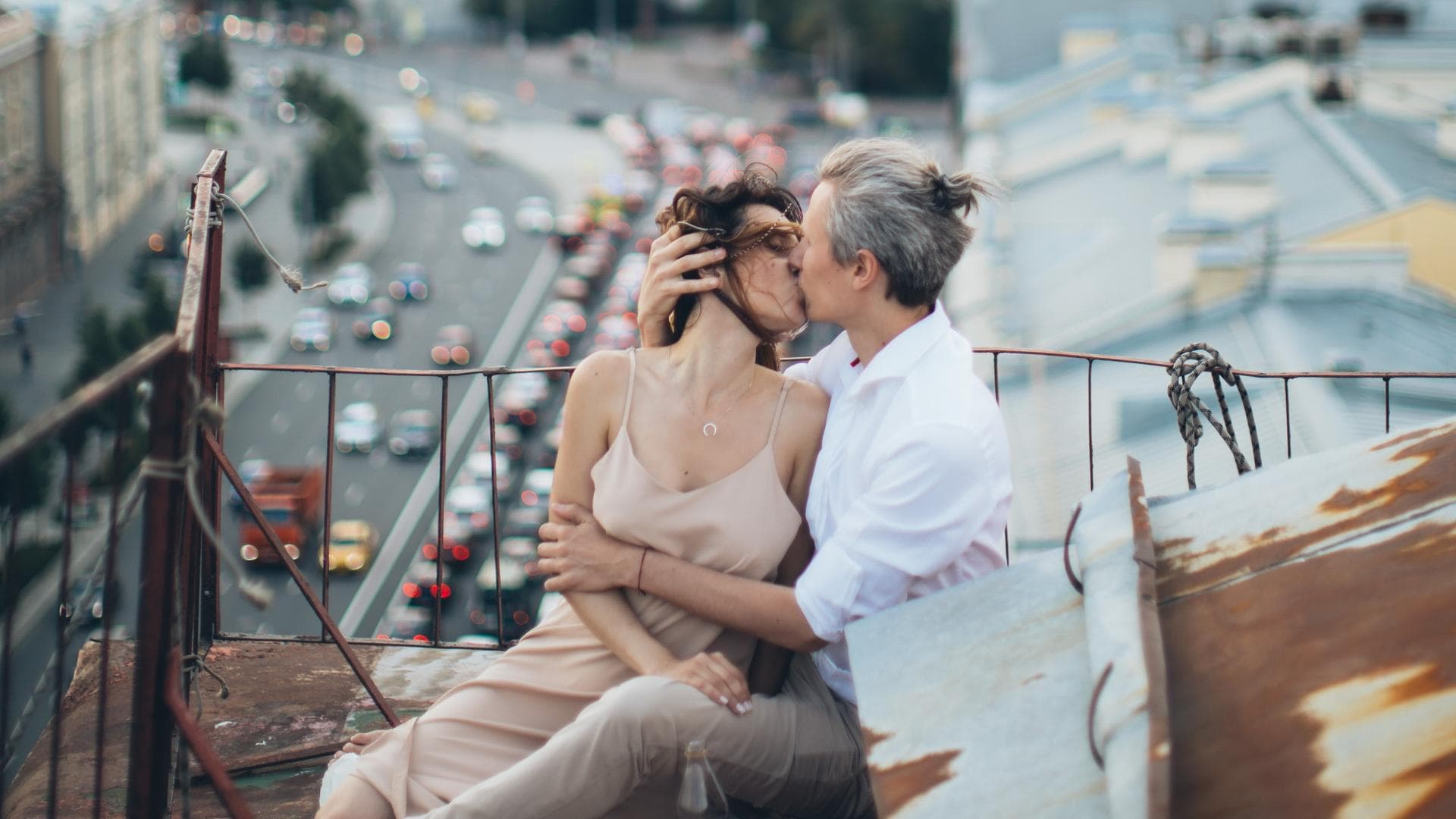 Eine Frau und ein Mann küssen sich auf einem Dach