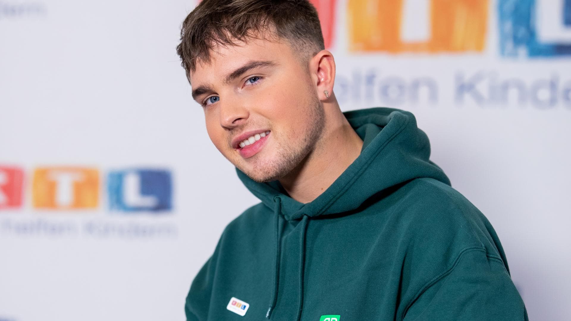 Mike Singer im grünen Hoodie, tätowiert