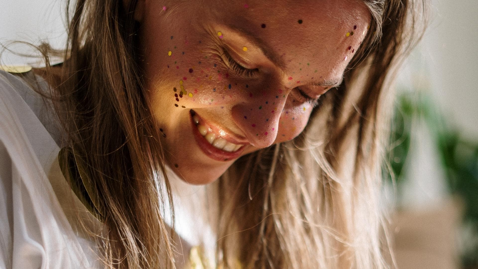 Frau mit Glitzer im Gesicht lacht