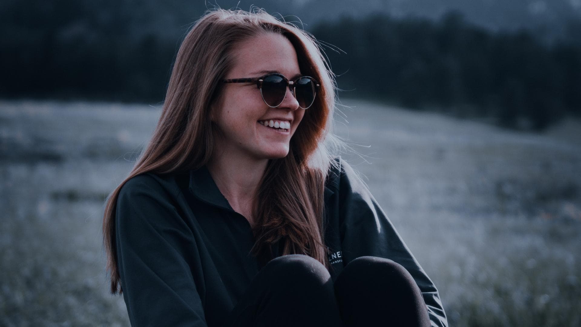 Frau mit Sonnenbrille lacht 