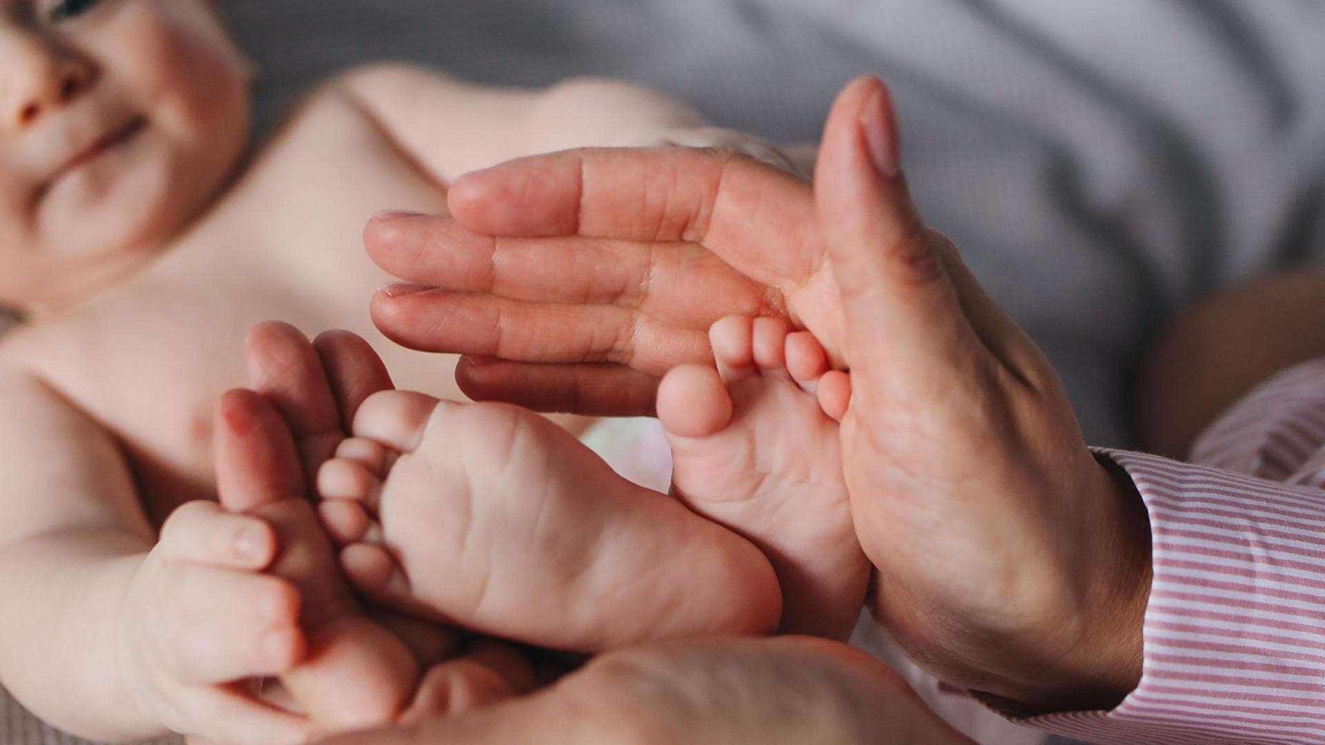 Frau haelt Babyfüße