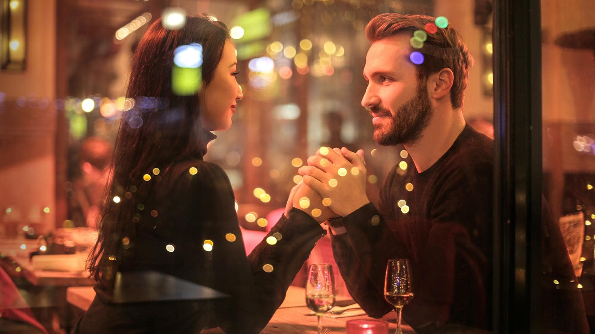 Mann und Frau halten Hände im Lokal