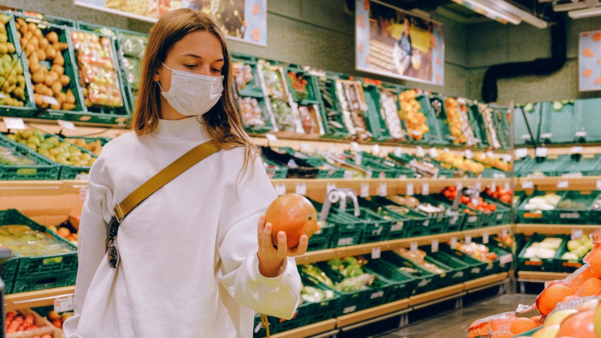 Frau im Supermarkt in der Obst- und Gemüseabteilung