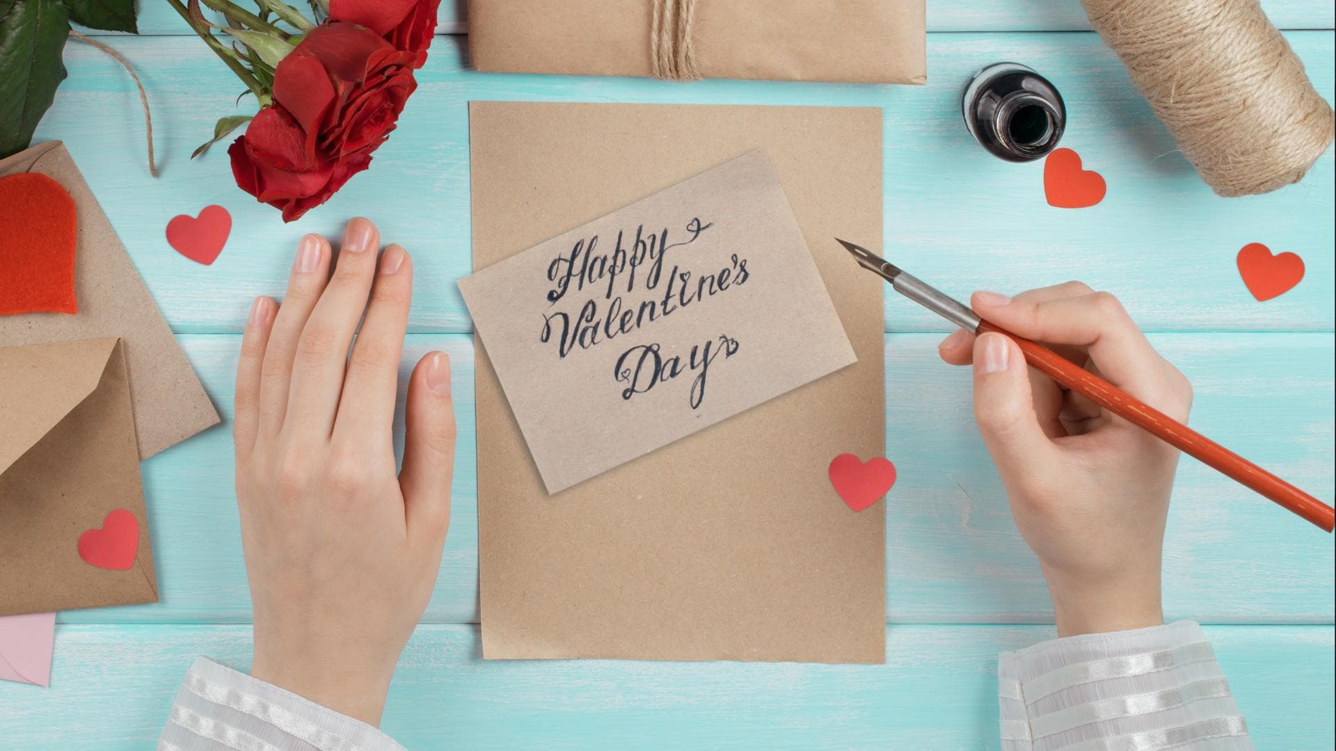 Valentinstag Sprüche: Zwei Hände schreiben eine Valentinstag Karte