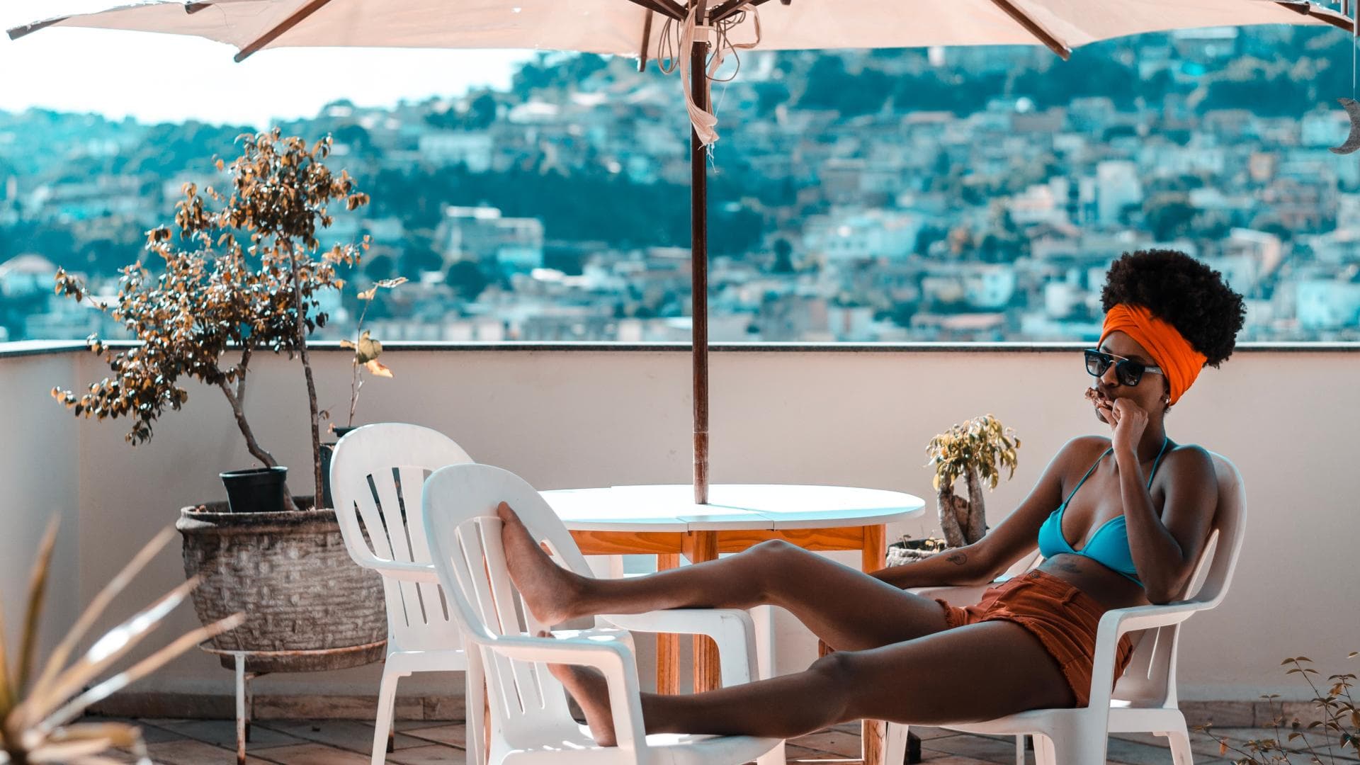 Frau liegt auf dem Balkon im Bikini