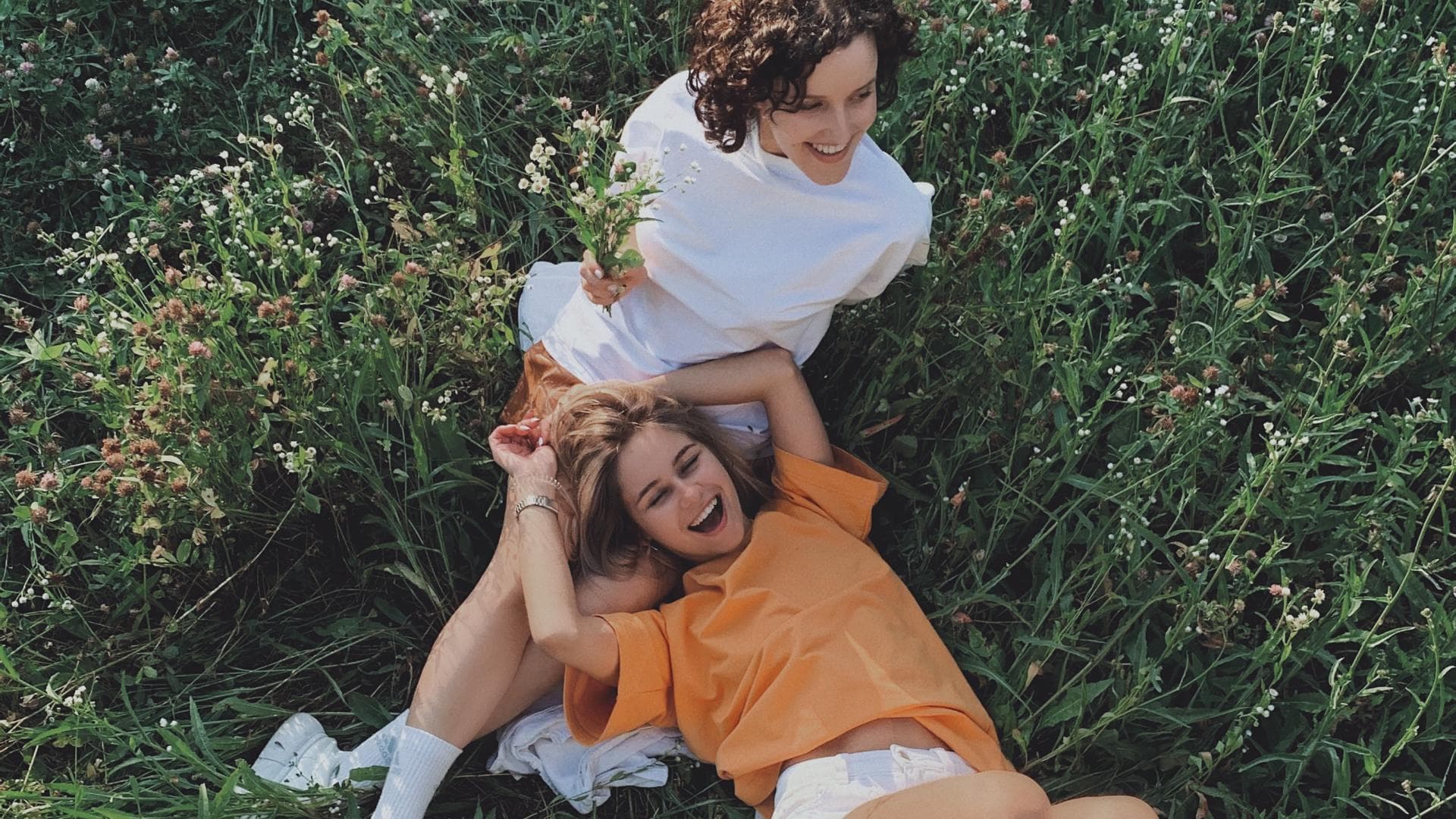 Horoskop der Woche: Zwei Frauen liegen in einem Feld