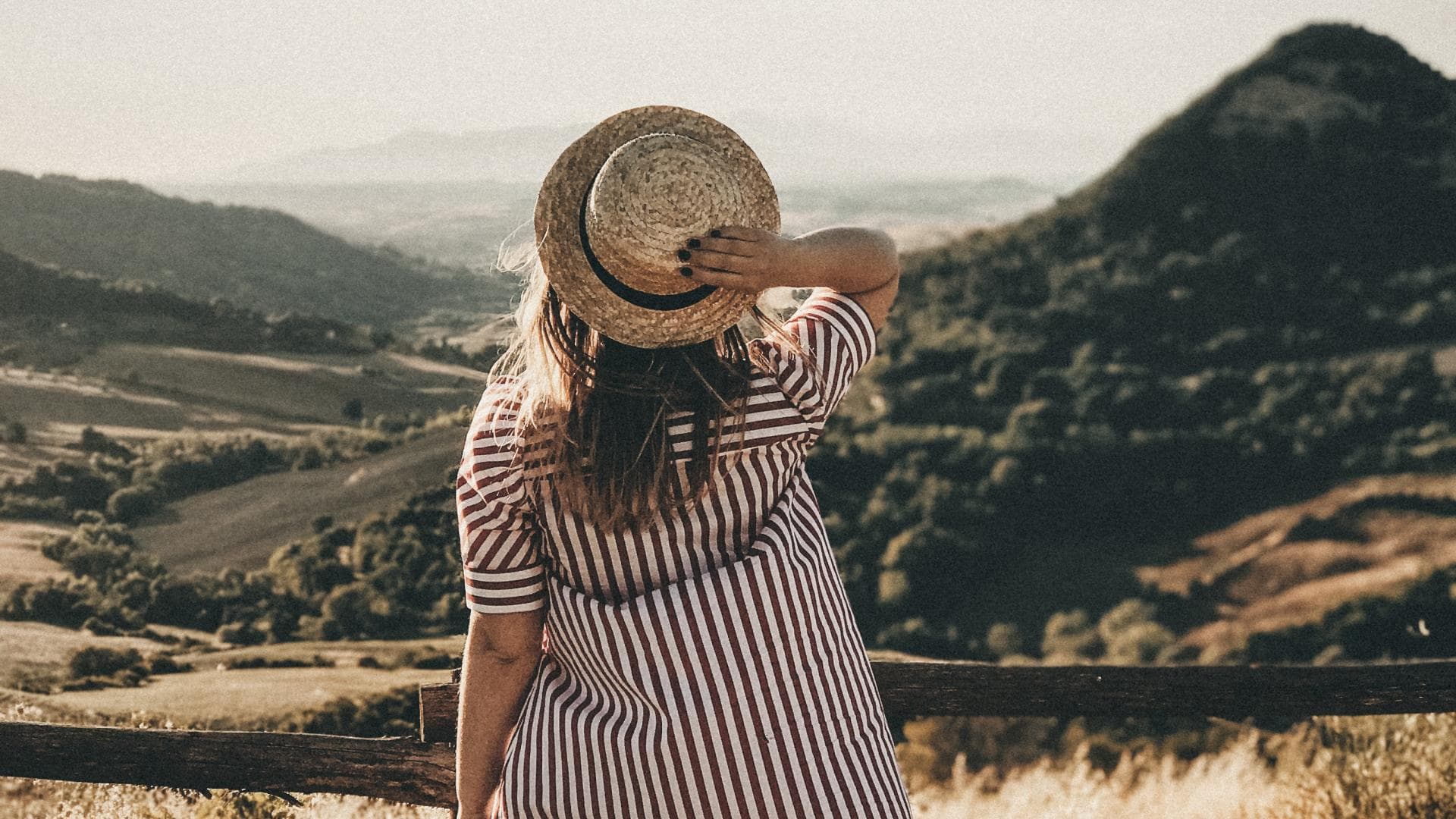 Horoskop: Frau steht mit Hut im Feld