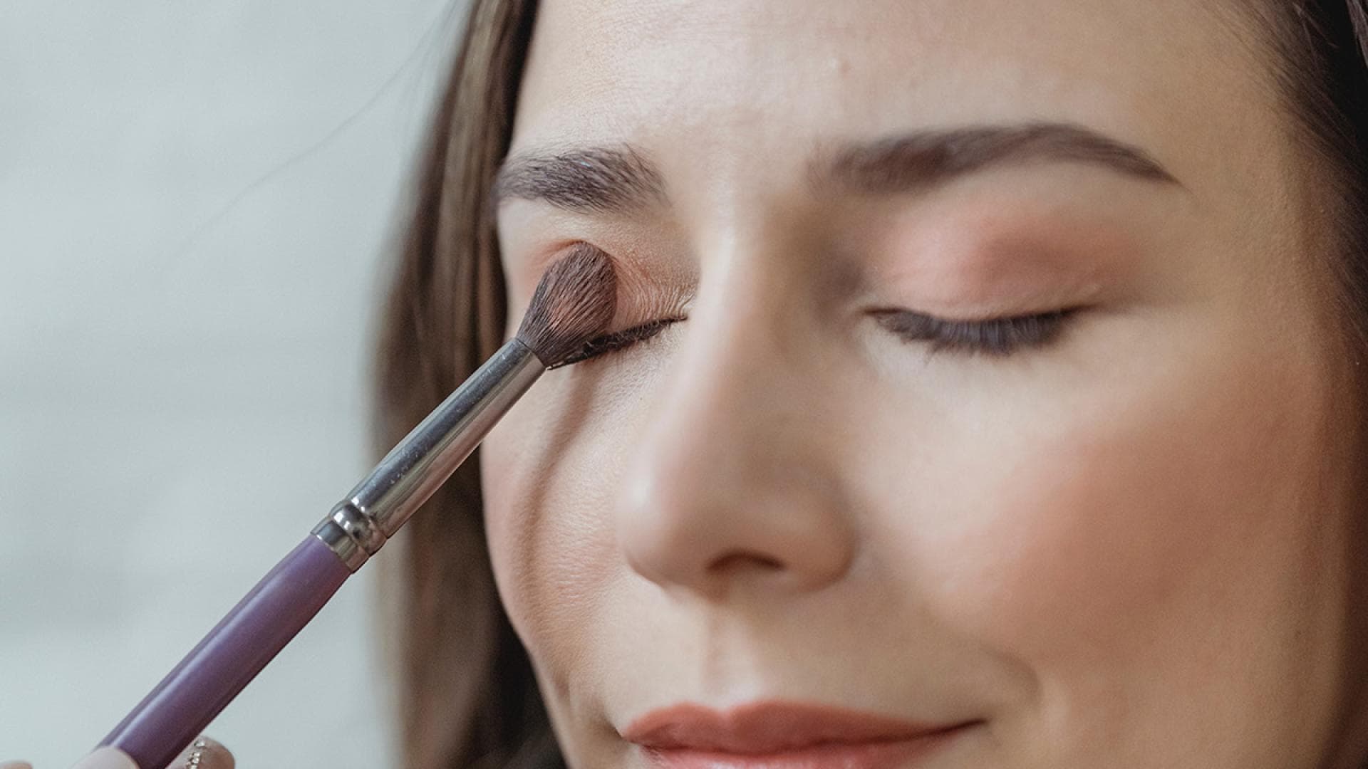 Junge Frau trägt Lidschatten auf