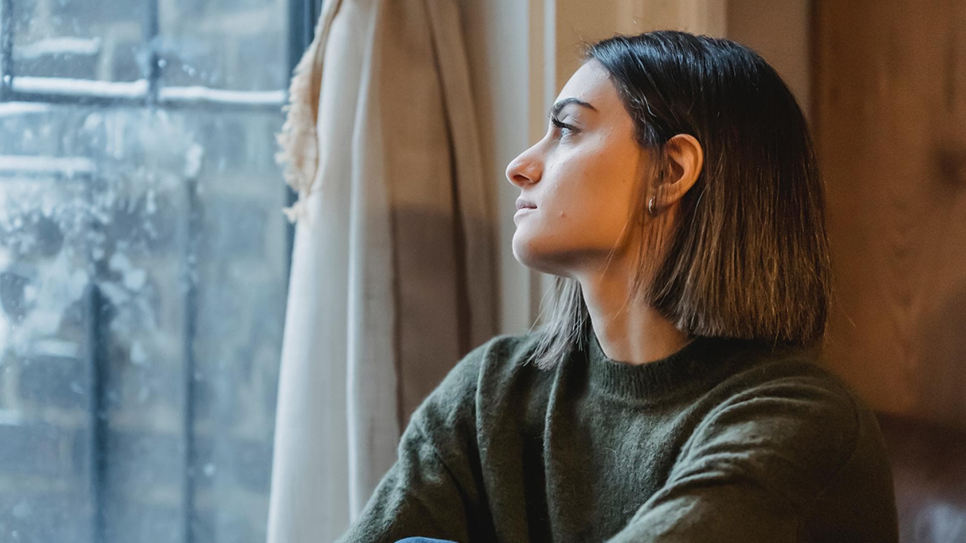 Frau schaut aus dem Fenster