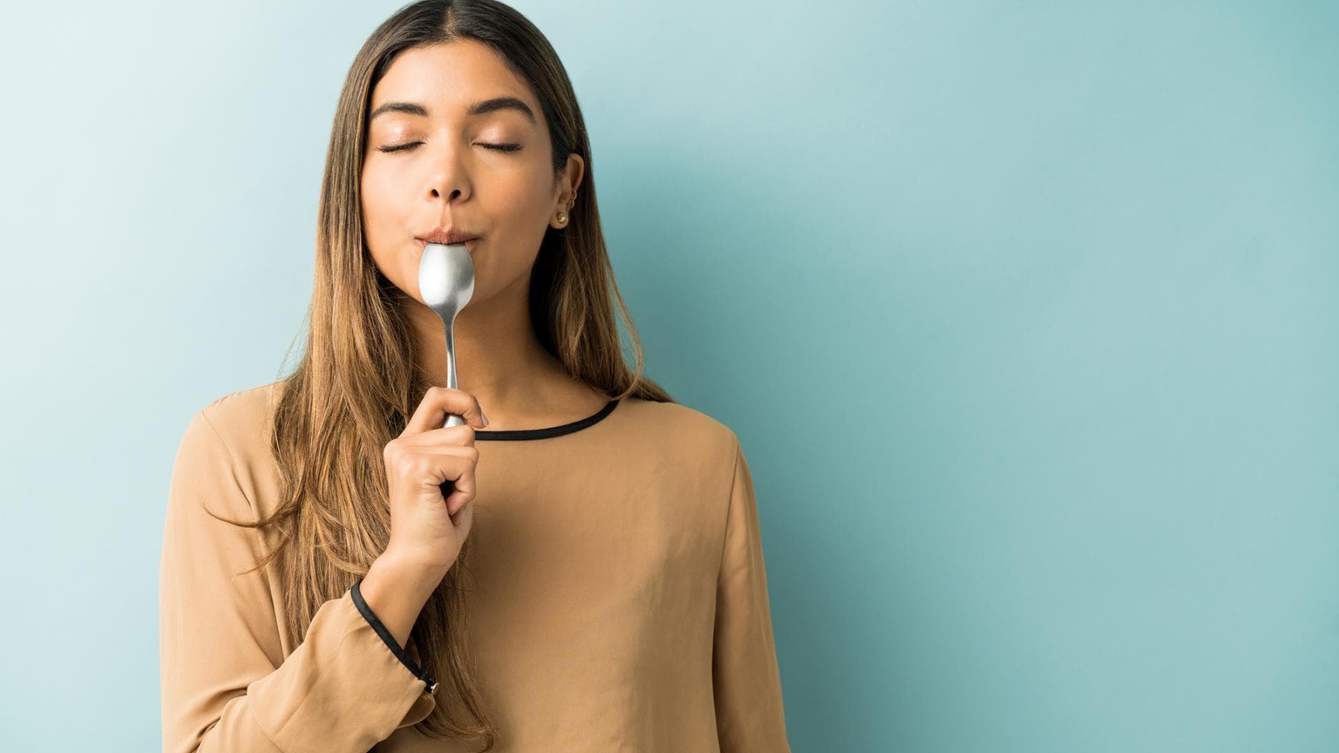 Frau hält Löffel im Mund