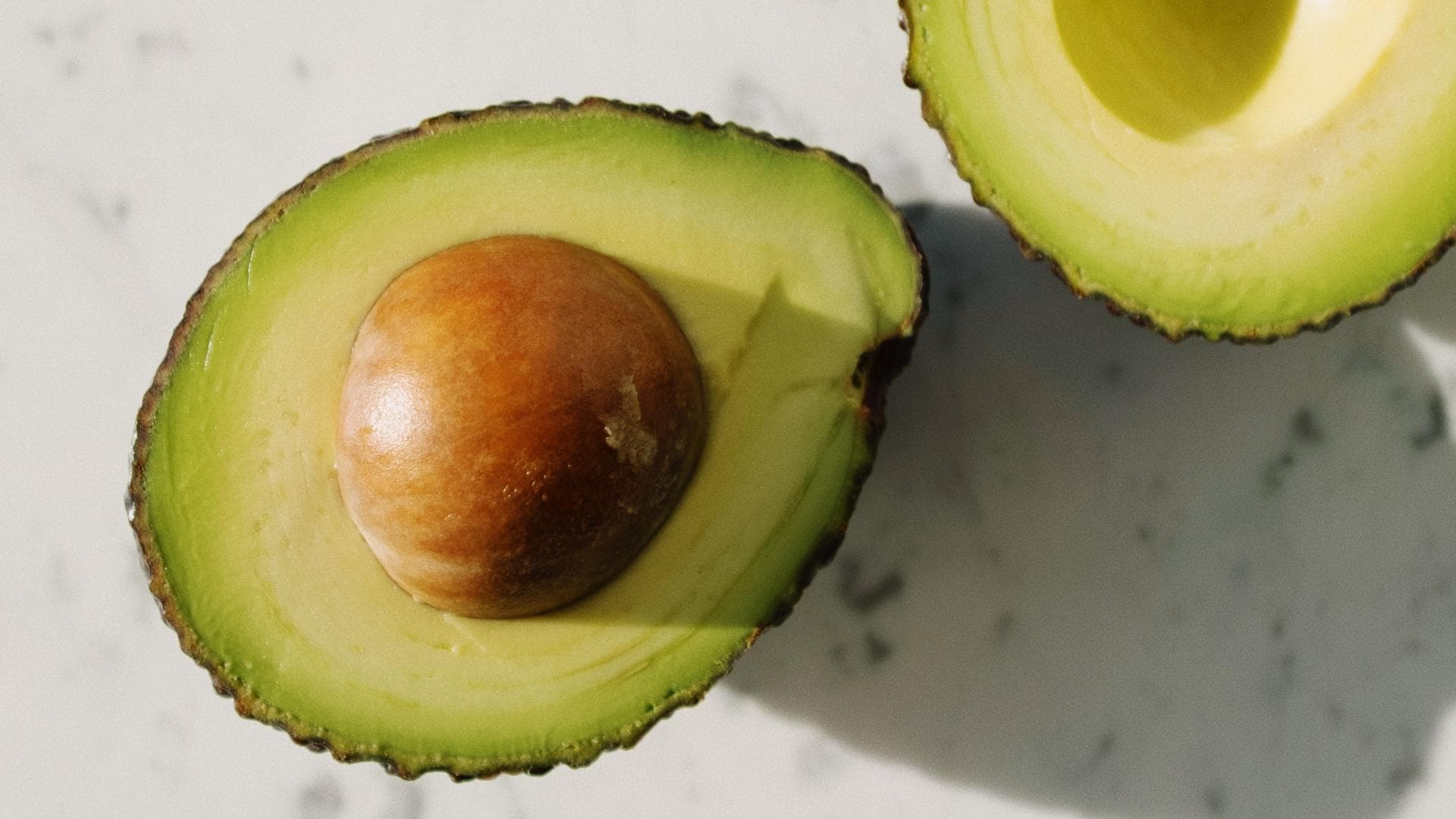 Avocadohälften auf Marmortisch