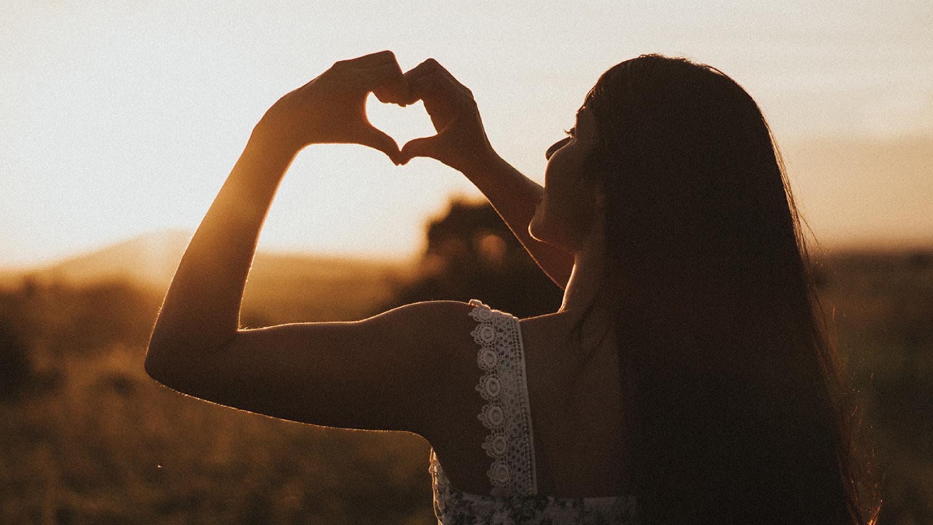 Frau formt ein Herz mit Händen