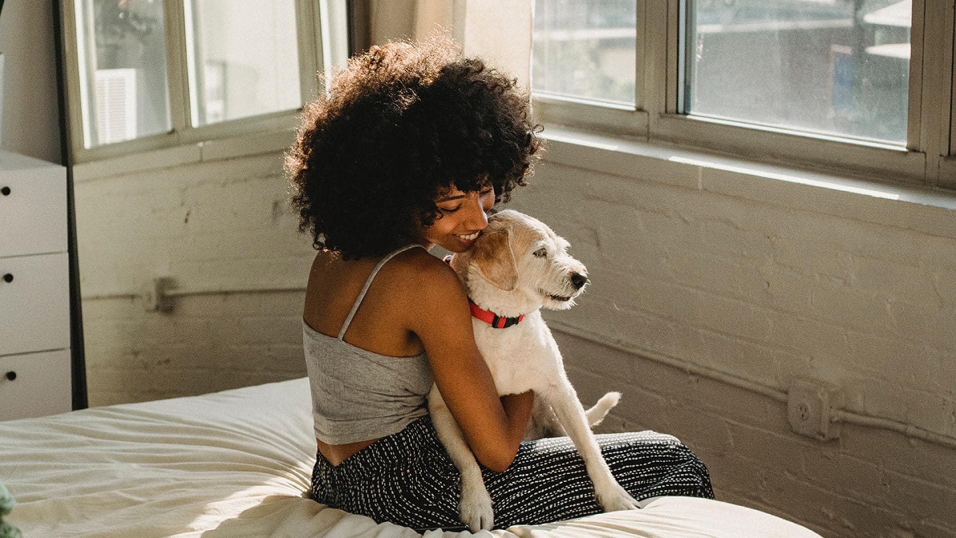 Frau mit Hund auf Bett