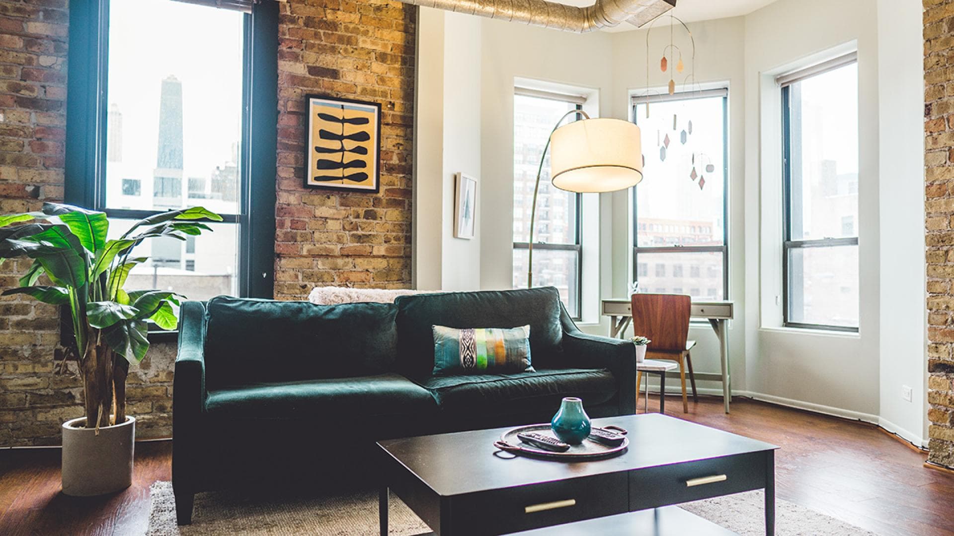 Zimmer mit Couch, Lampe, Tisch und Pflanzen
