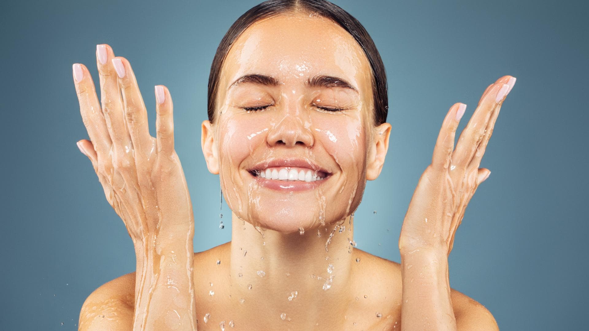 Frau wäscht sich mit Wasser das Gesicht 