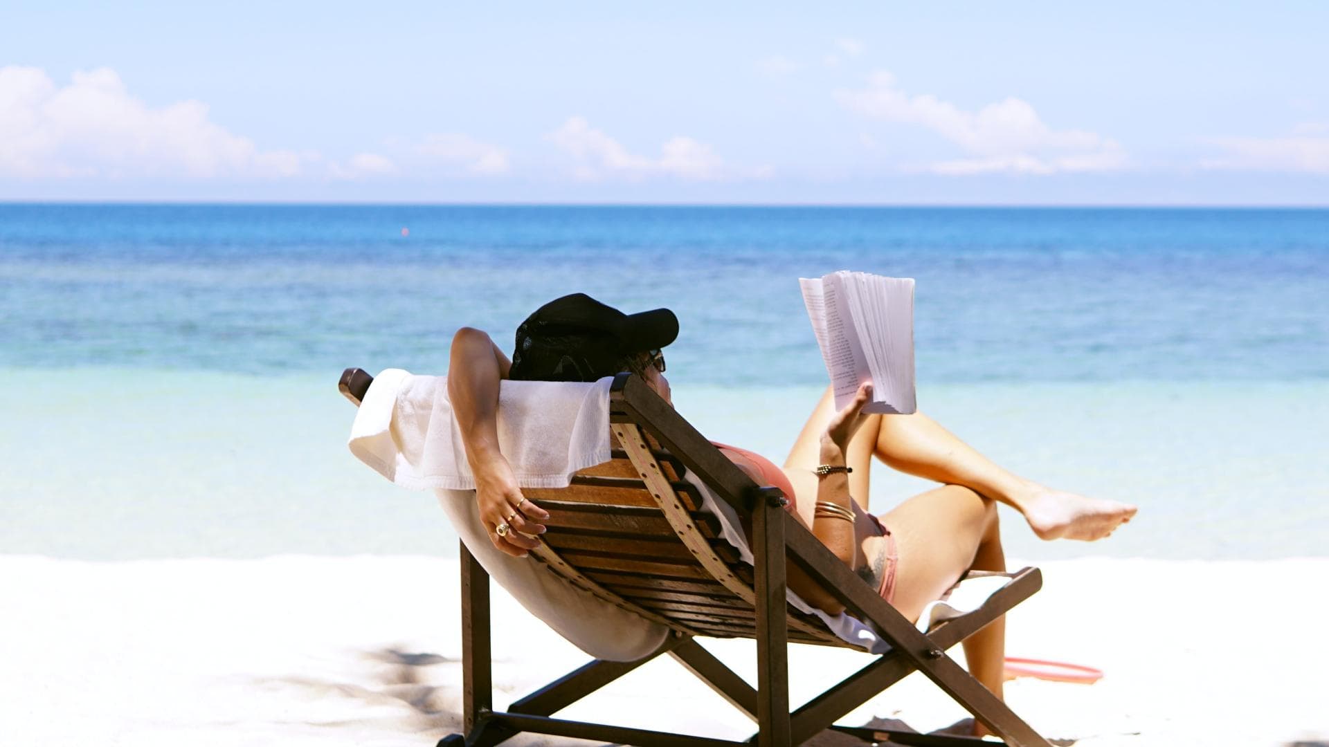 Frau liest Buch am Strand