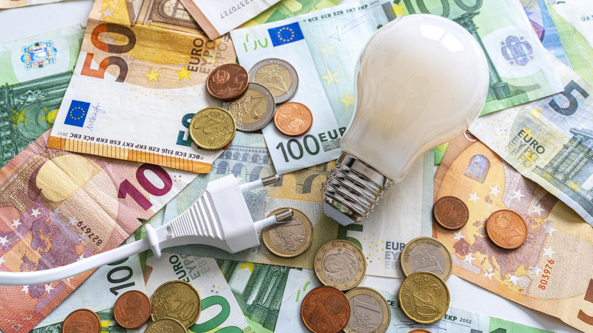 Glühbirne liegt auf Geld 