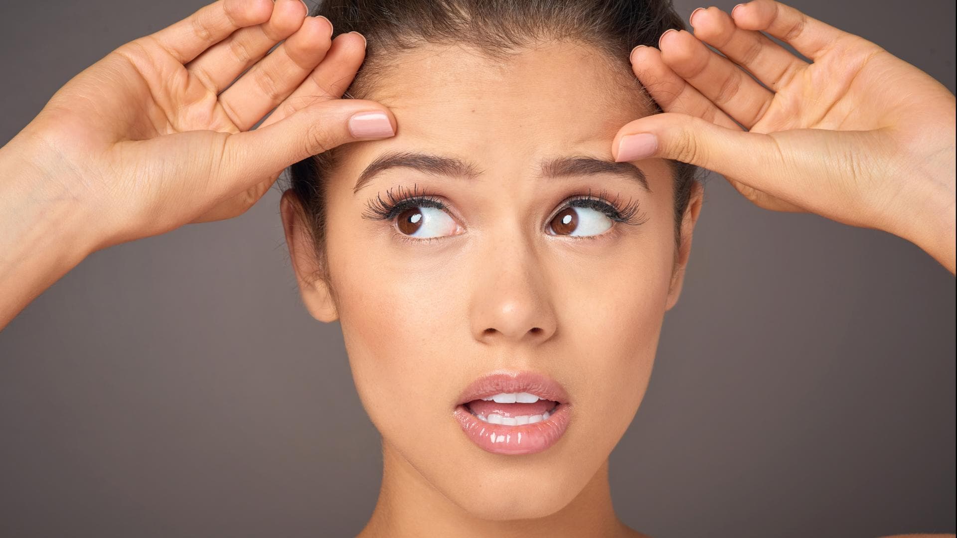 Frau zeiht sich Haut im Gesicht straff