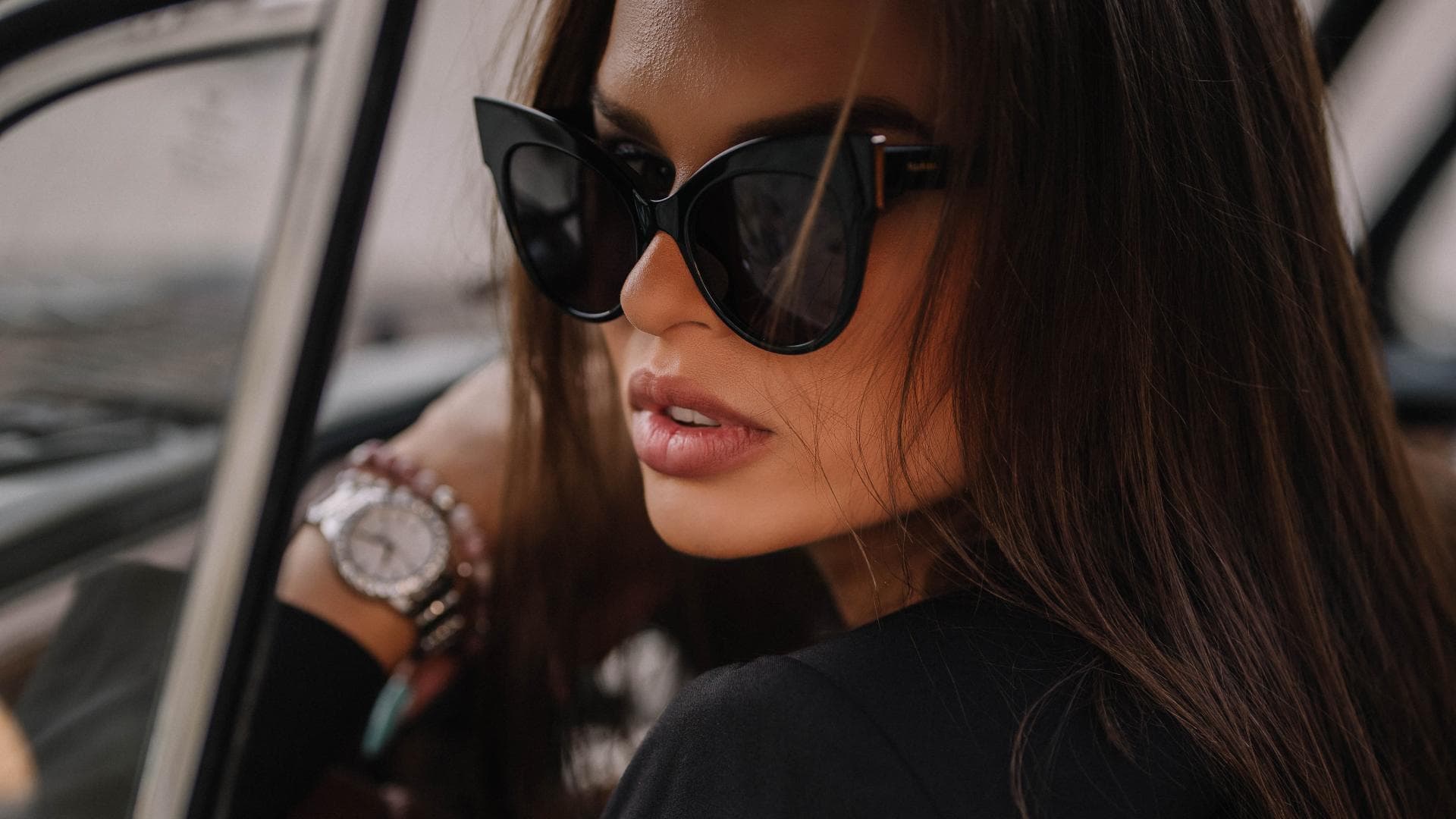 Frau mit Sonnenbrille sitzt im Auto