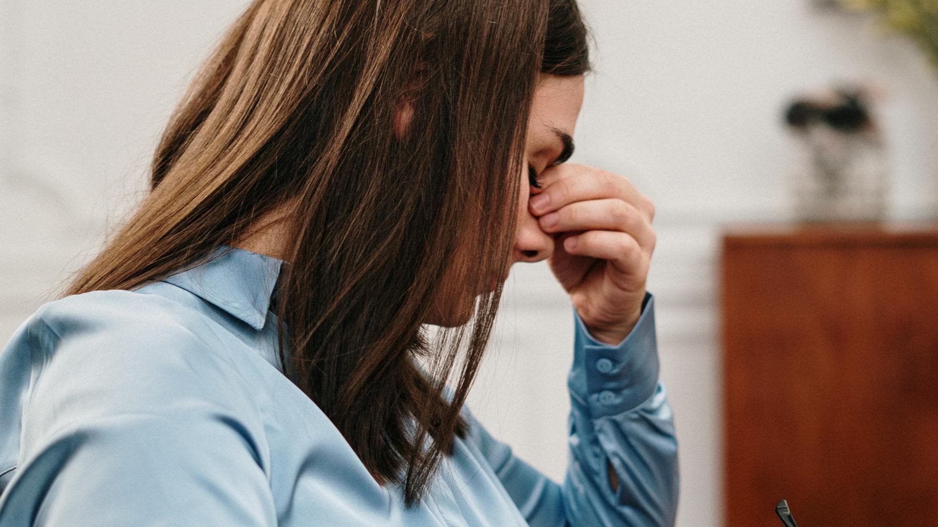 Verzweifelte Frau hält sich Hand an den Kopf