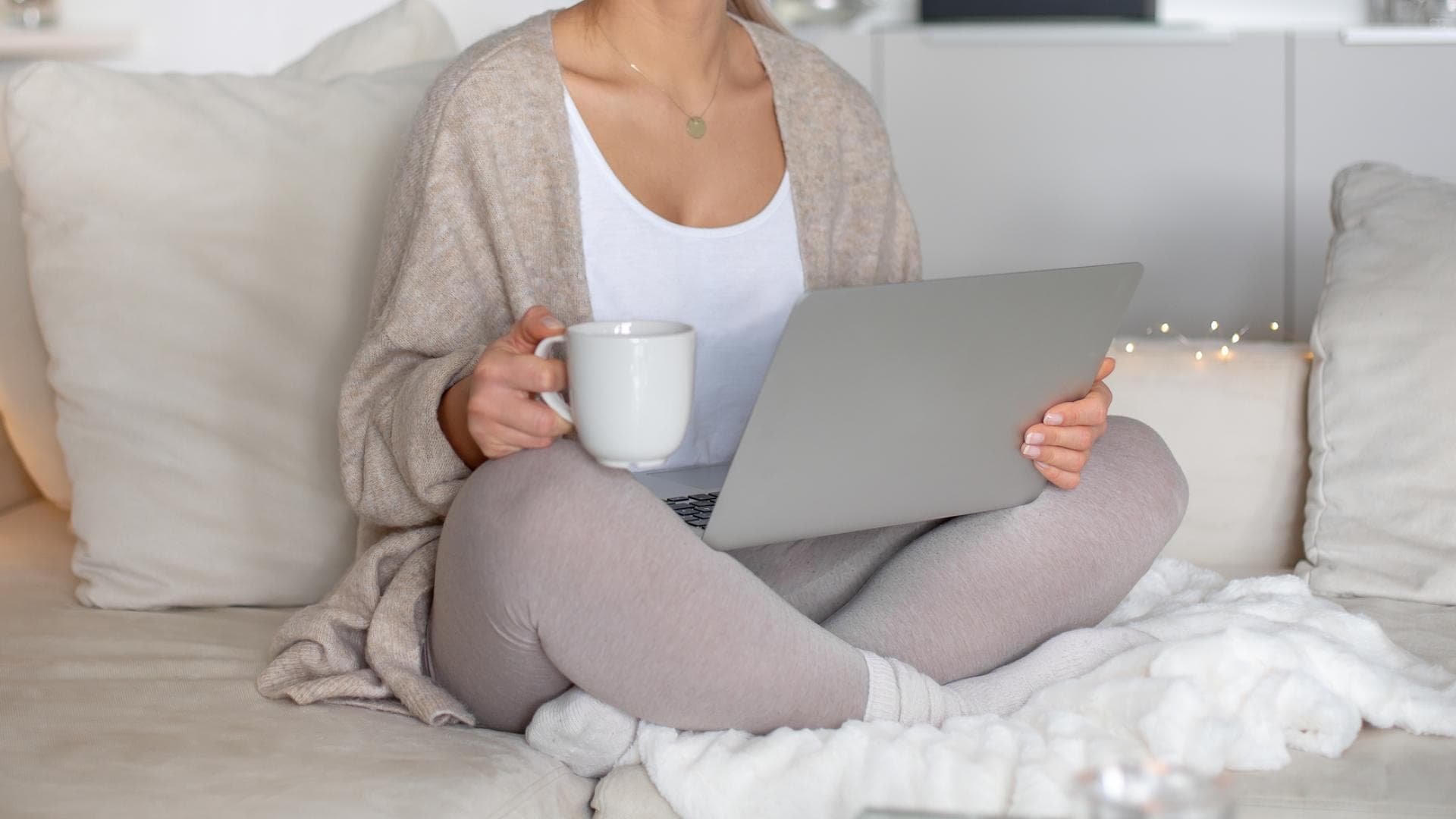 Frau sitzt in Thermowäsche Zuhause auf der Couch