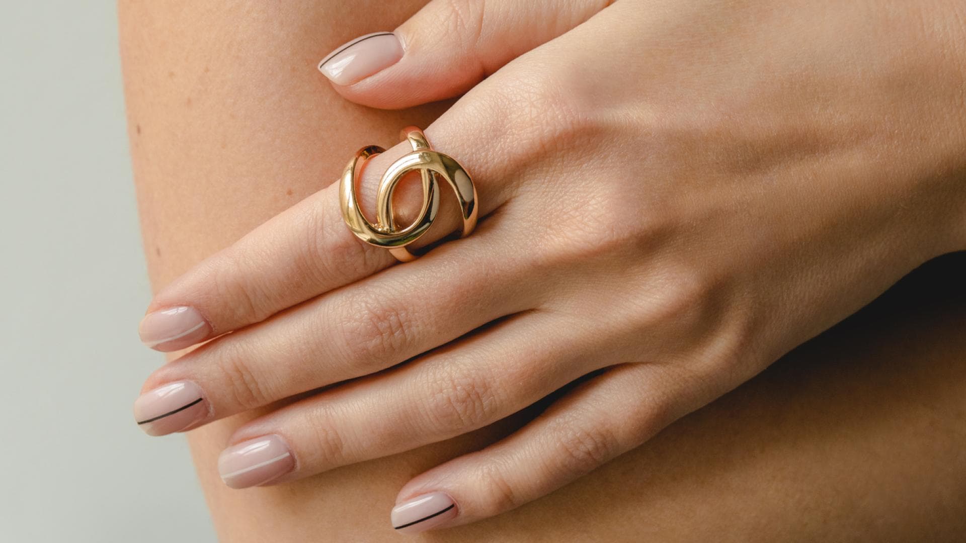 Fingernägel lackiert mit goldenem Schmuck