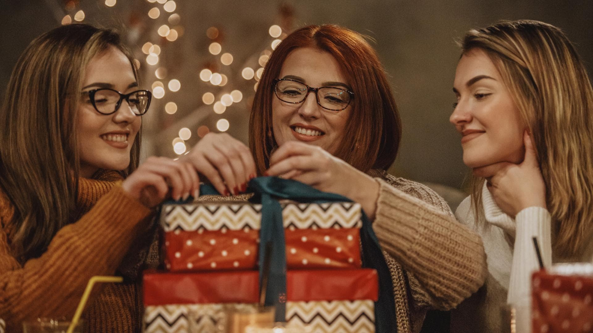 zwei junge Frauen mit Mutter und Weihnachtsgeschenken